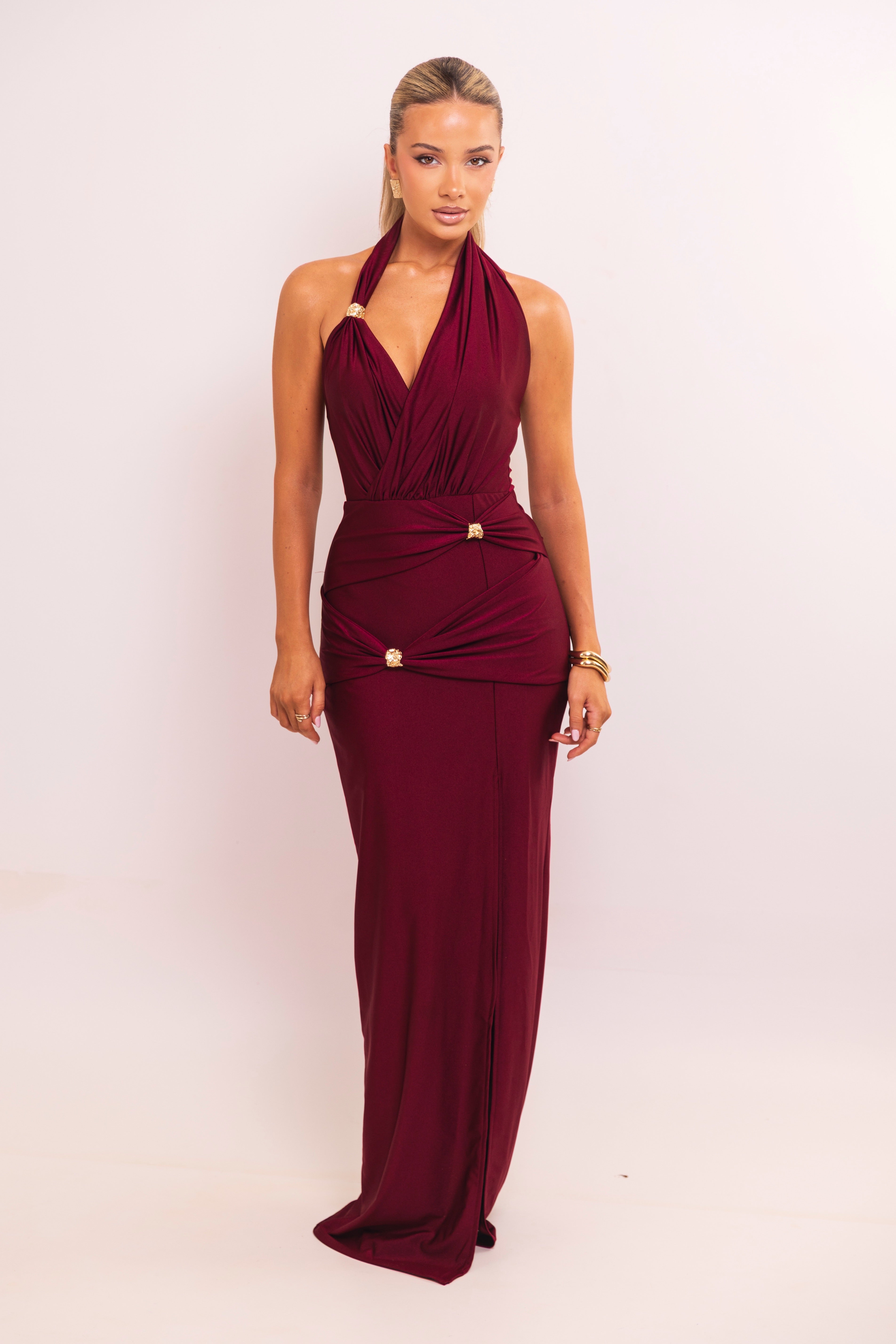 Burgundy halter gown with gold accents and deep V neckline