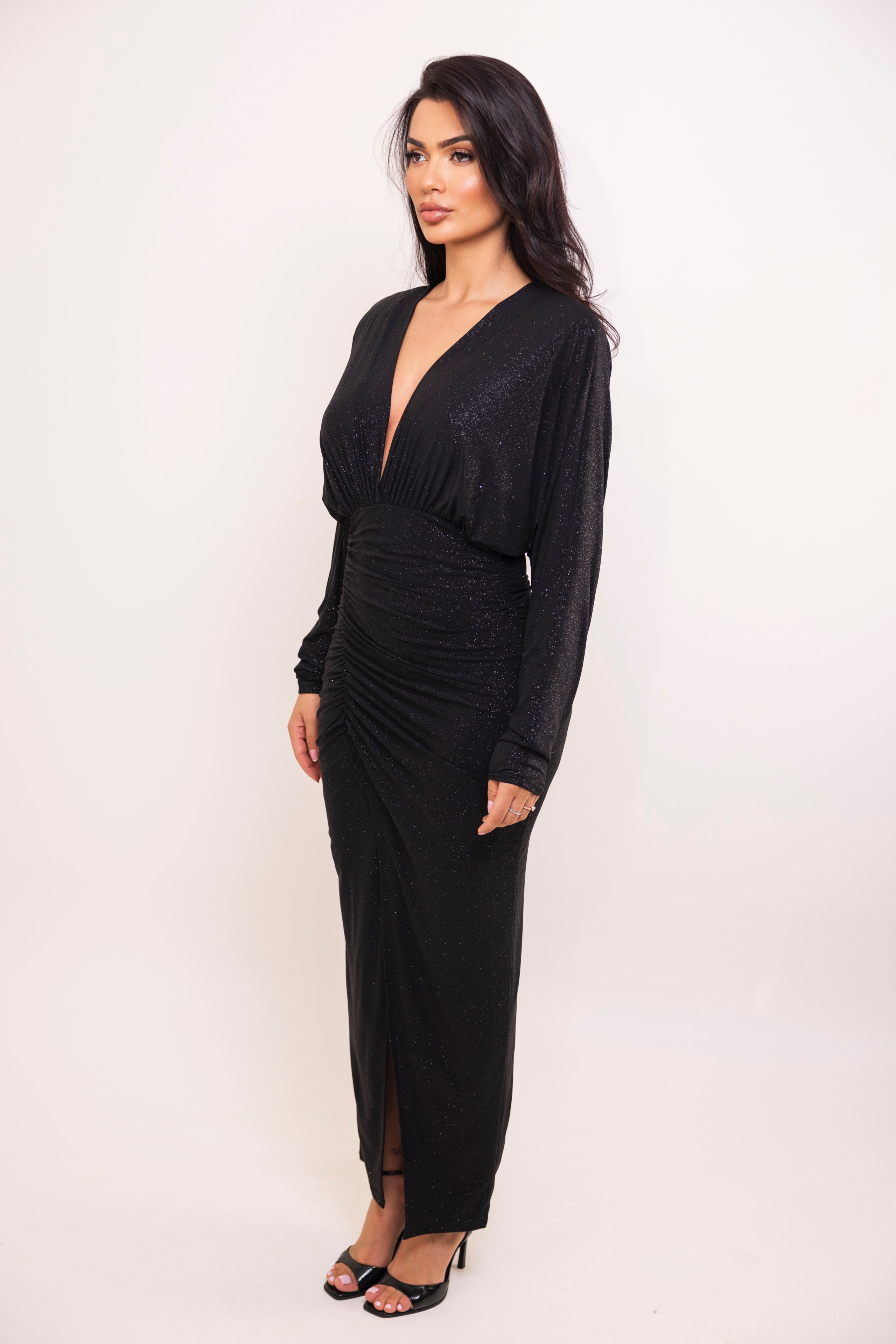 Back view of shimmering black floor-length dress with fitted silhouette.