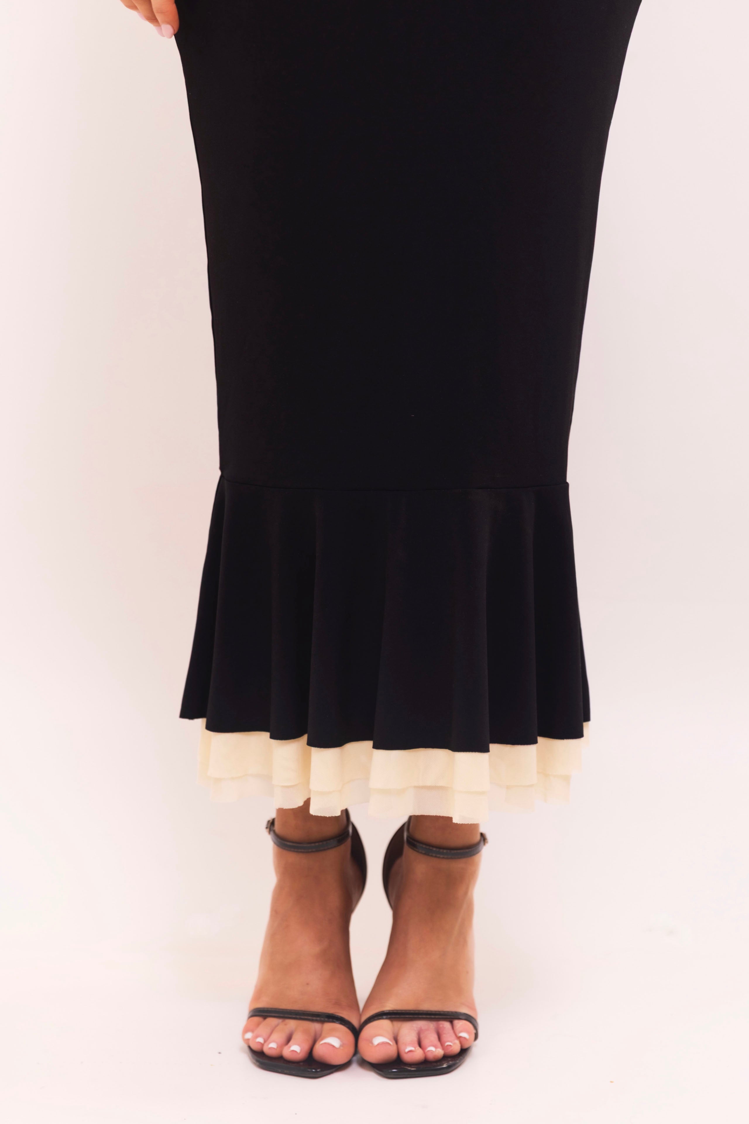 Modern black midi dress with contrasting details and soft curves