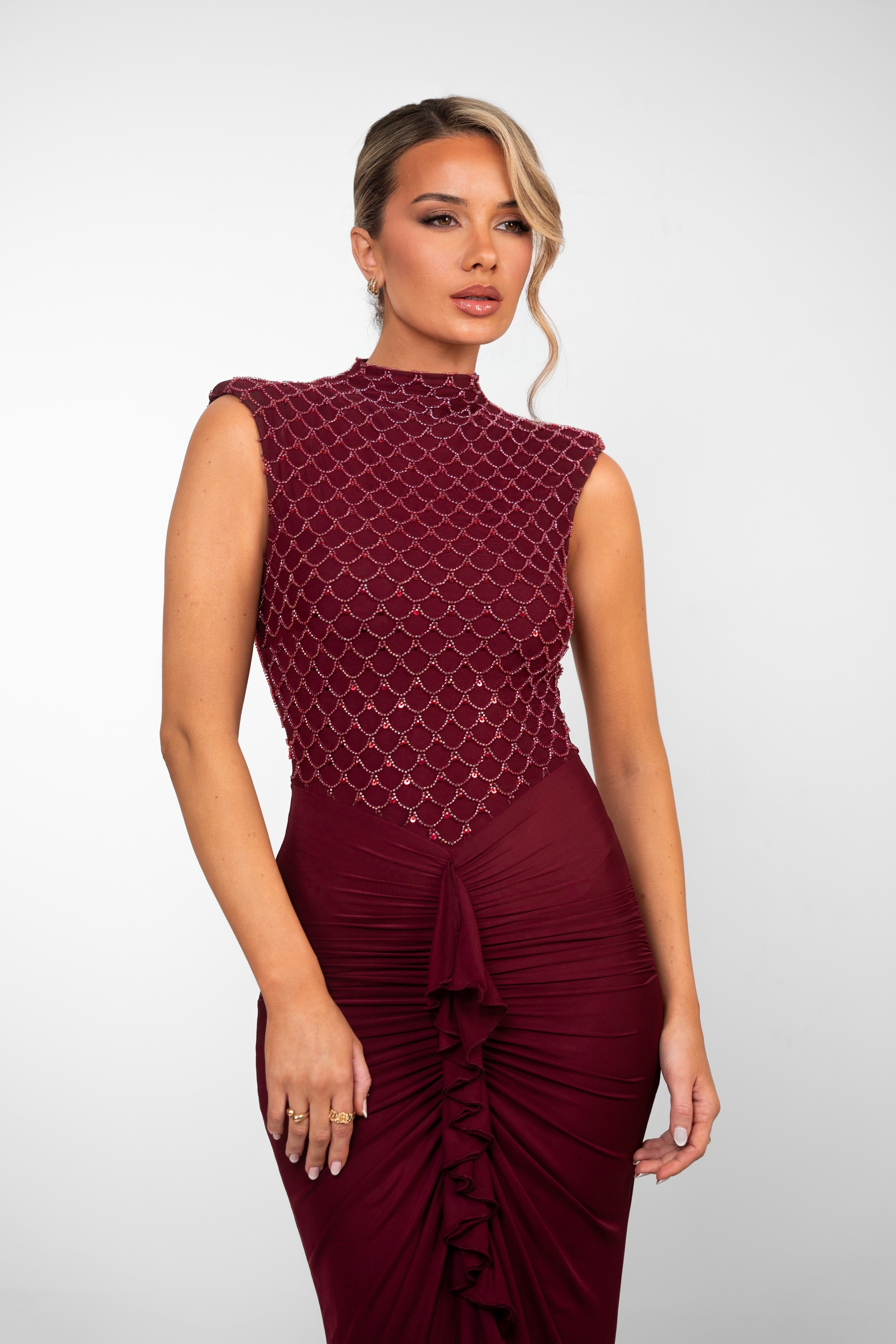 Elegant burgundy evening gown featuring a textured bodice and gathered front panel