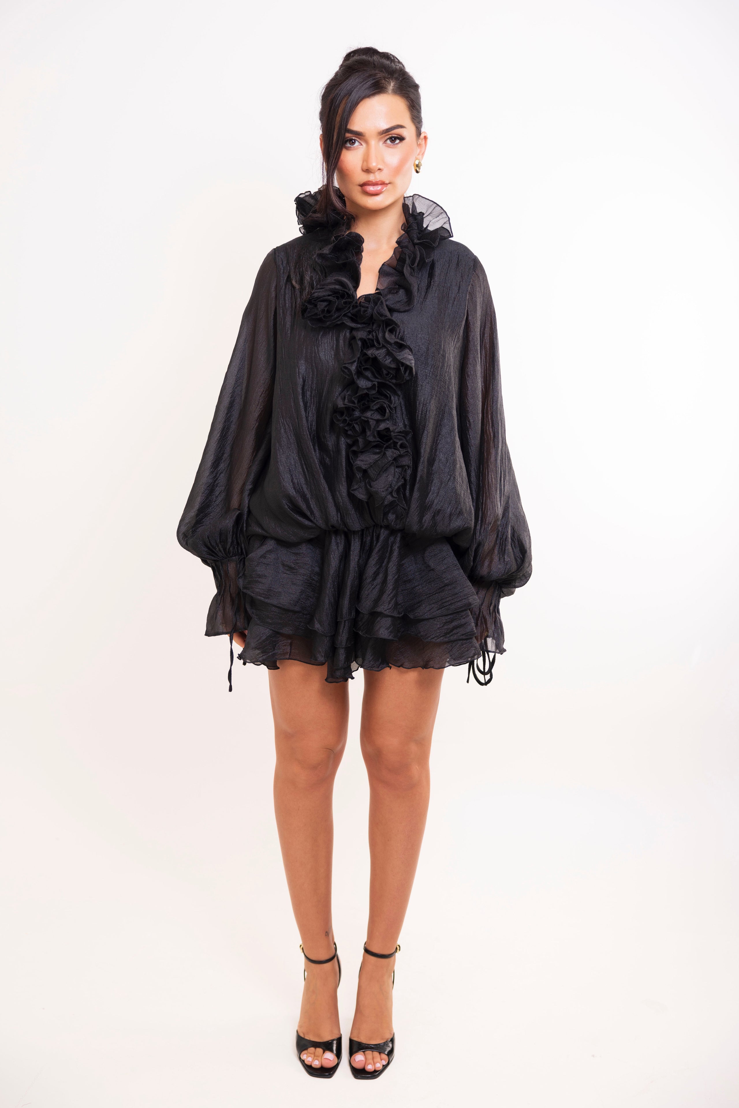 Black organza mini dress with ruffled neckline and tiered hem.