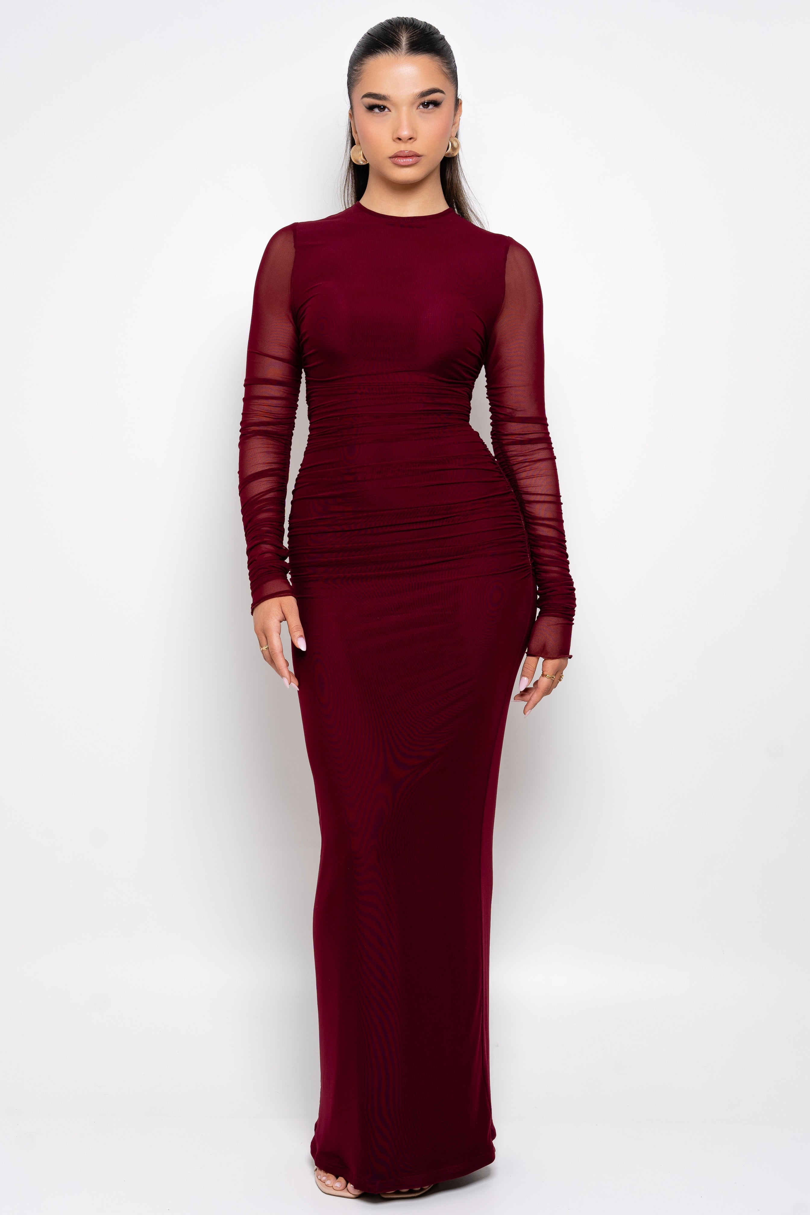 Elegant burgundy gown with sheer sleeves.