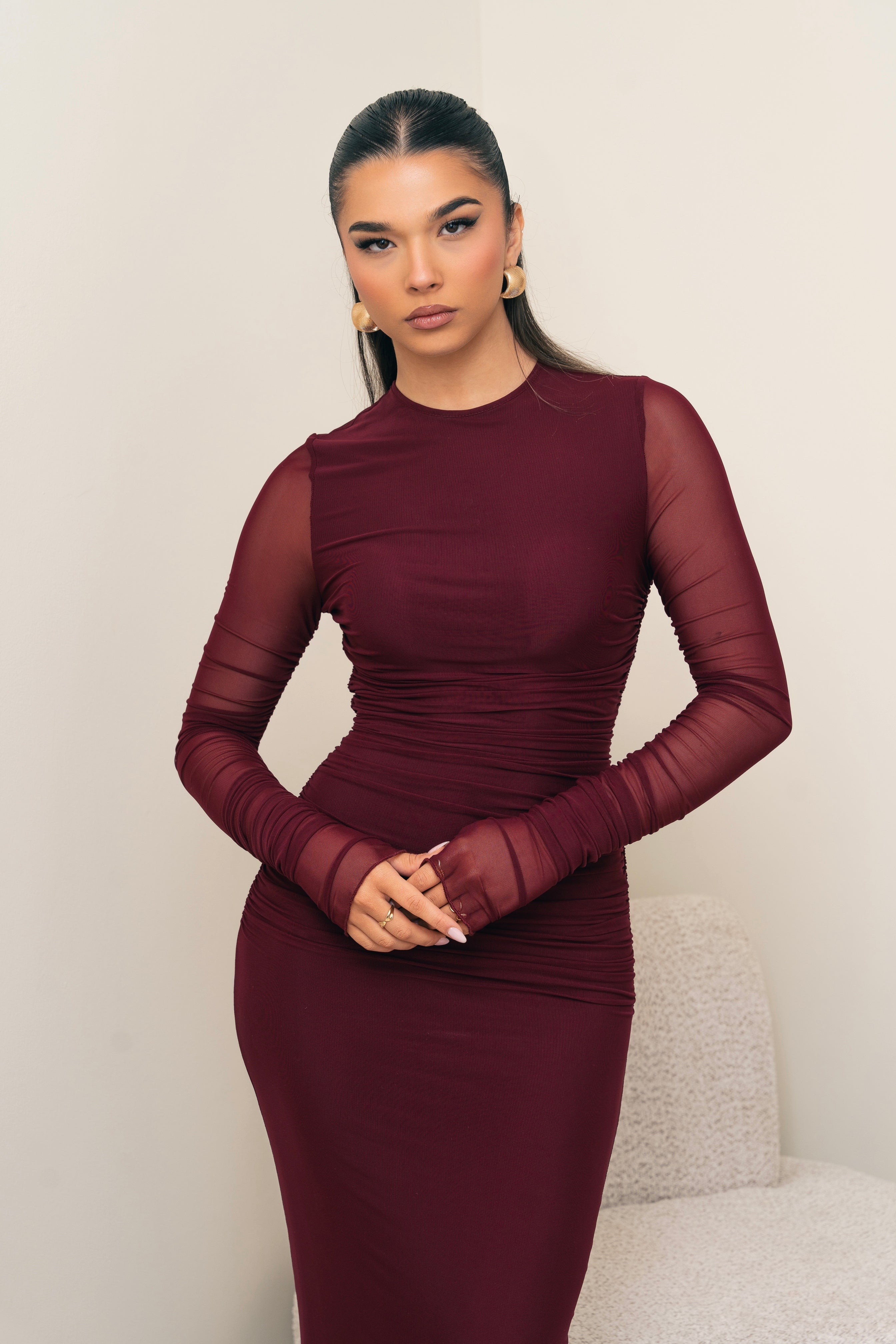 Long-sleeve ruched dress in deep red.