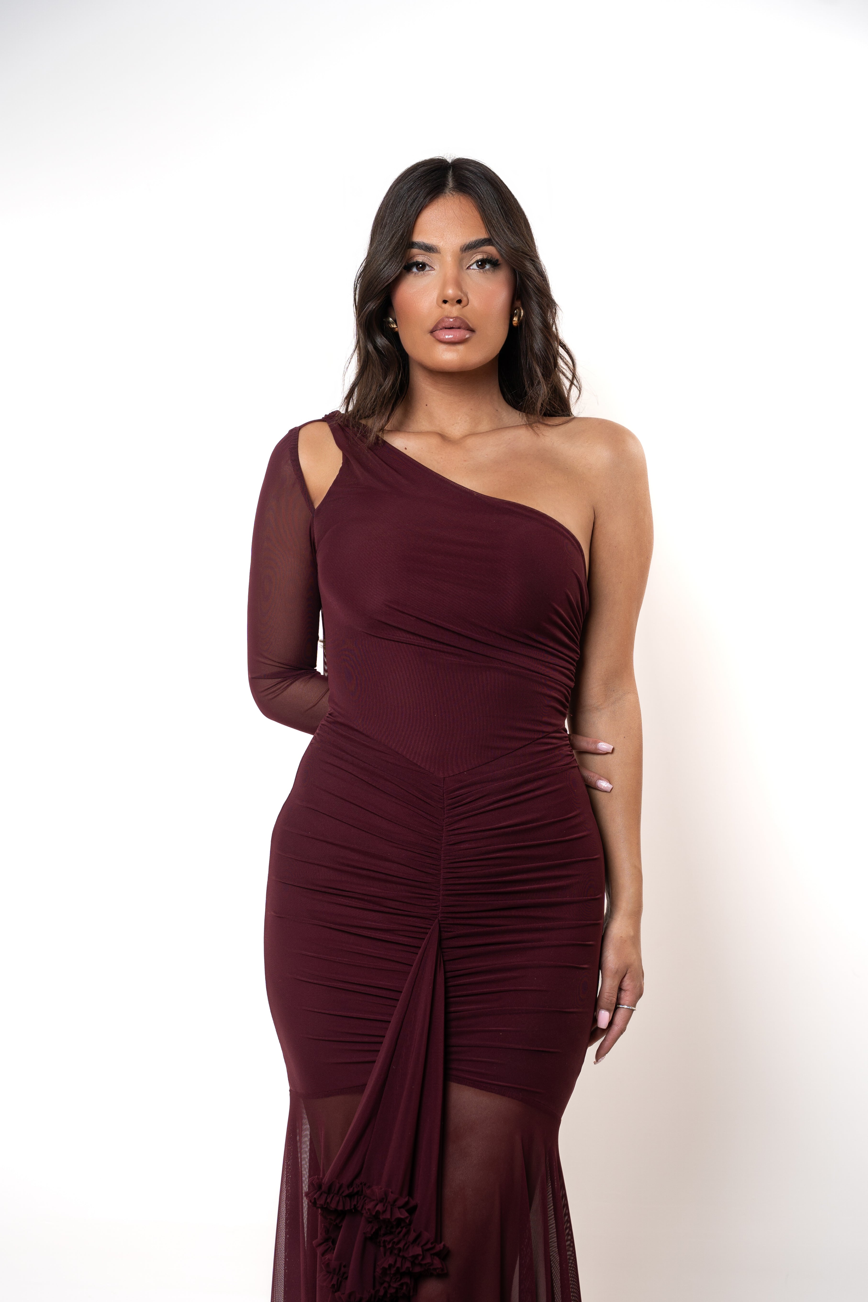 Woman wearing a burgundy one-shoulder dress on a white background