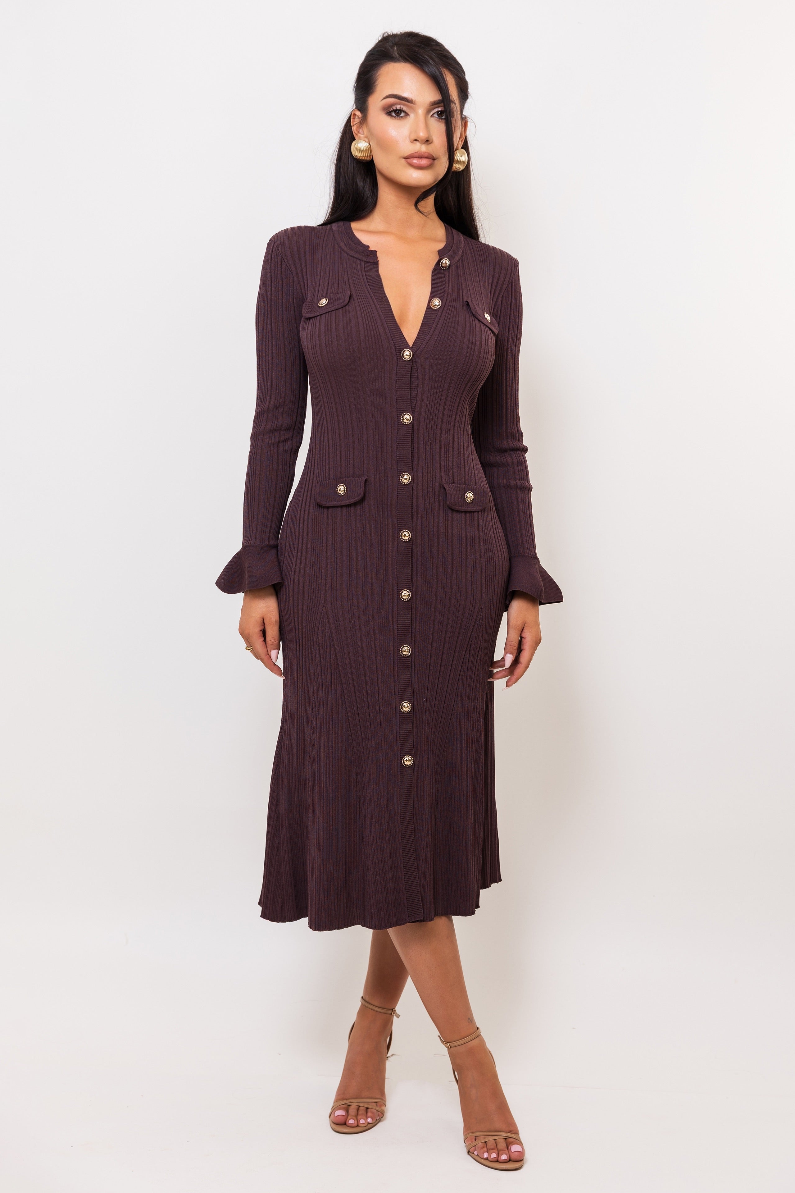 Woman wearing a dark brown ribbed dress with buttons on a white background