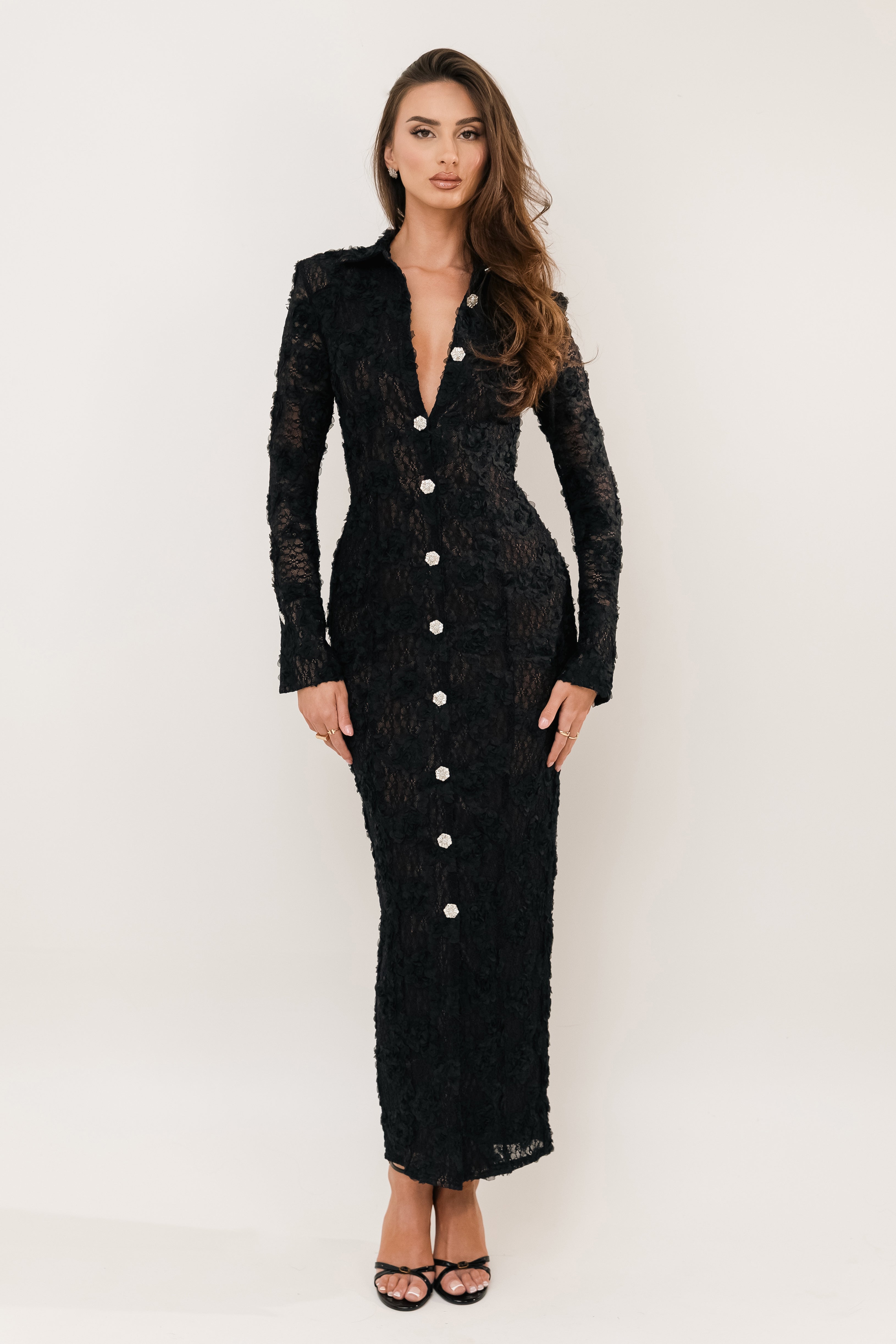 Woman wearing a black dress with white buttons on a white background