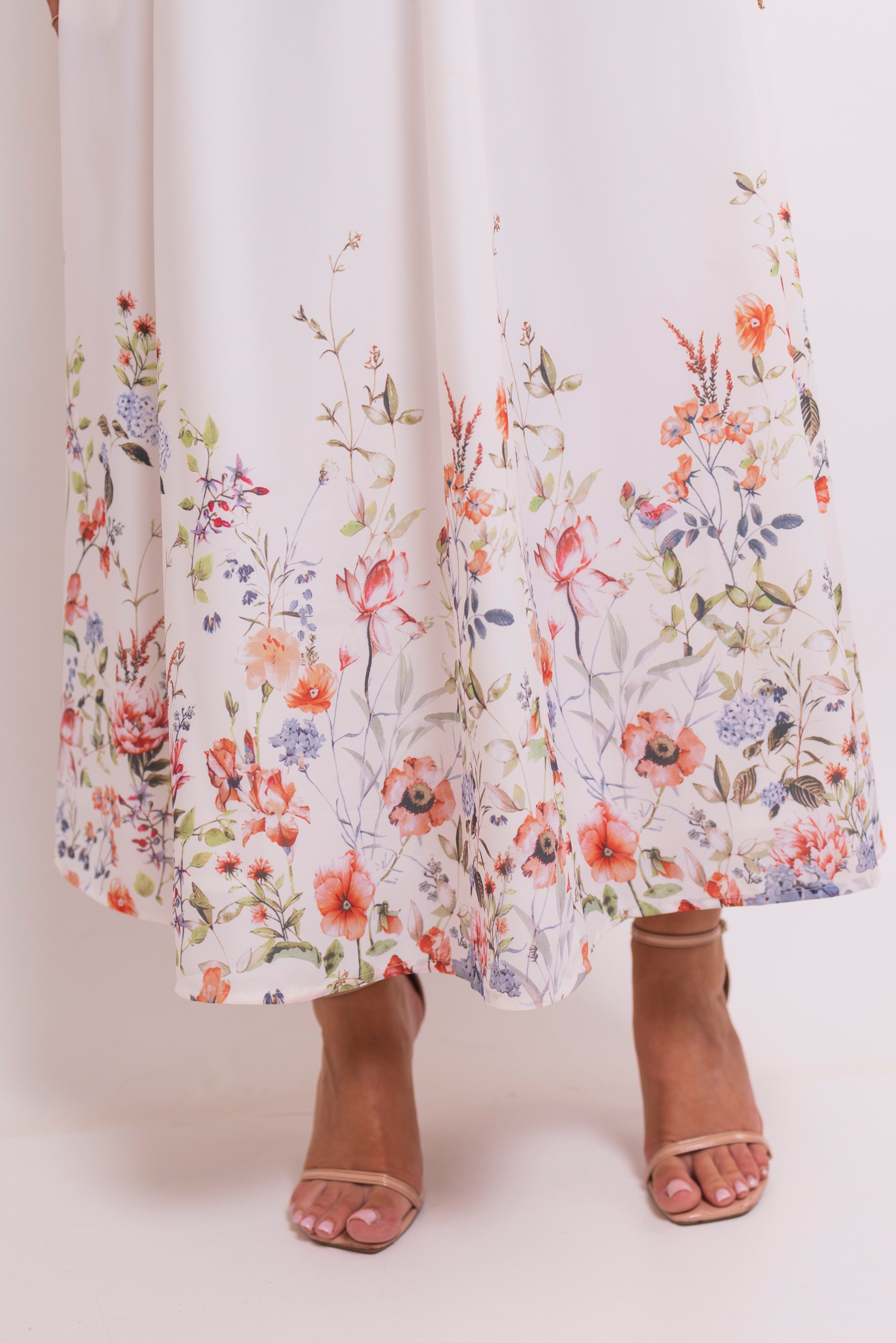 Close-up of the bottom floral pattern on a white dress.