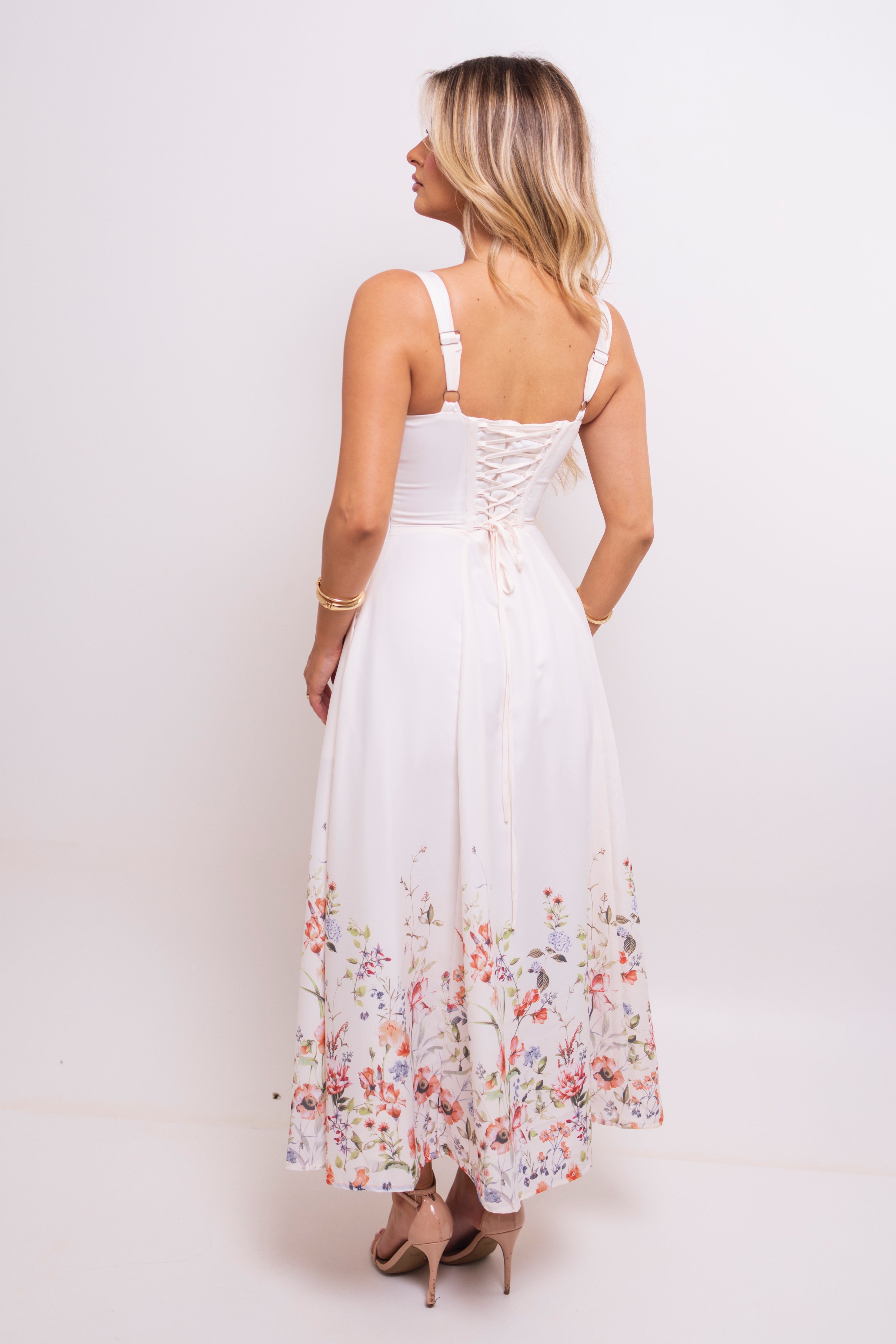 Back view of a model in a floral dress with lace-up detailing.