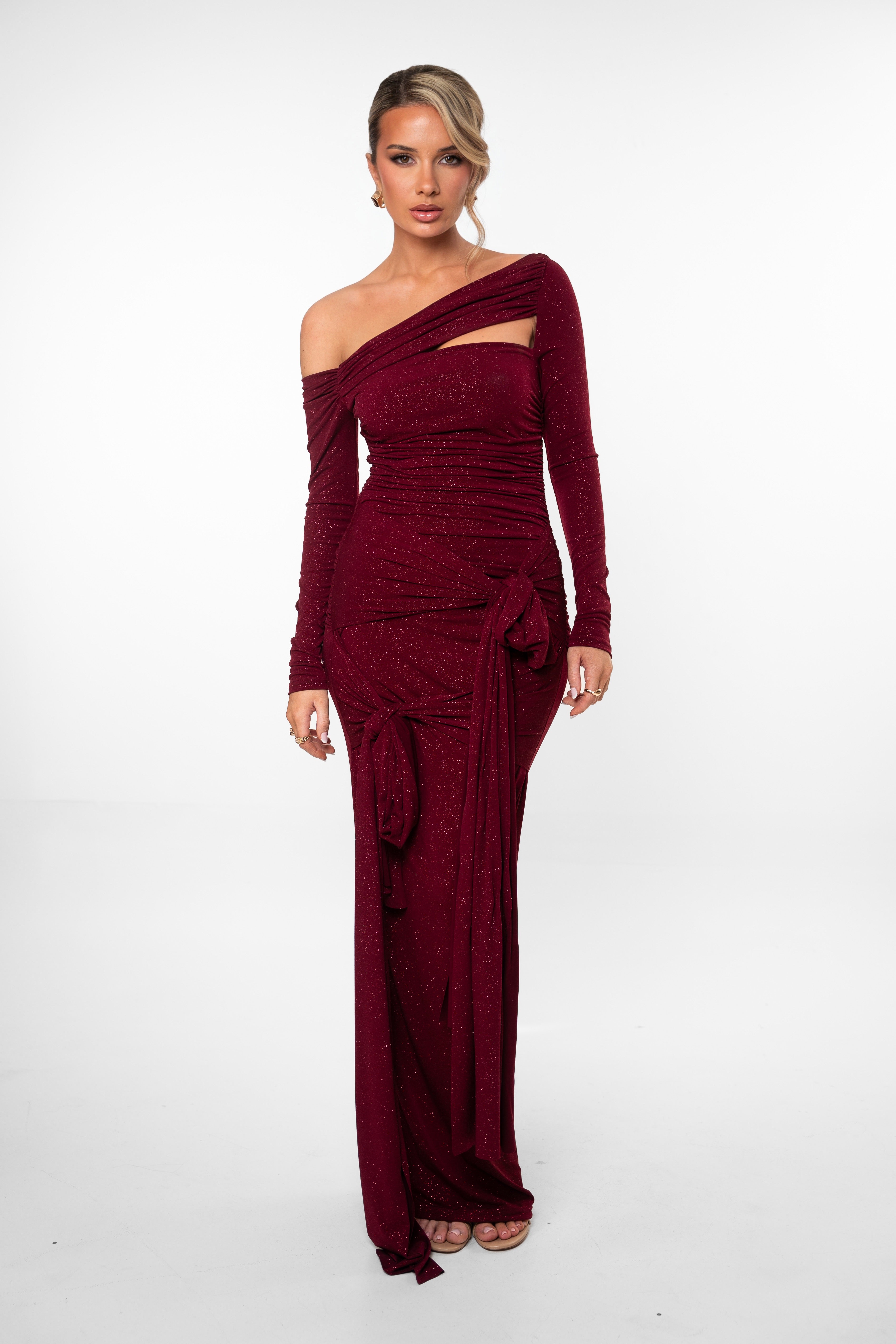 Woman wearing a burgundy off-shoulder dress on a white background