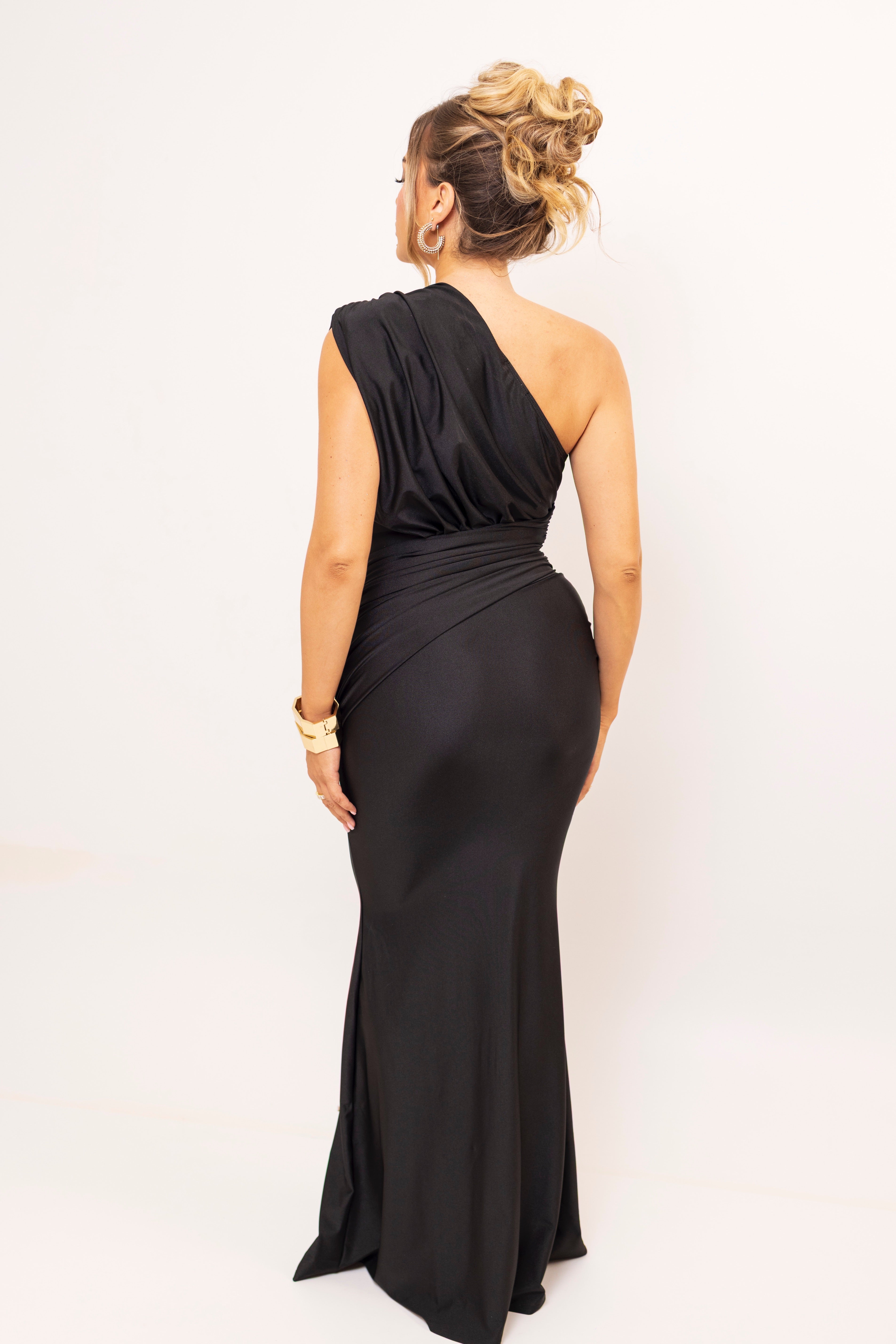 Back view of sleek black asymmetric dress.