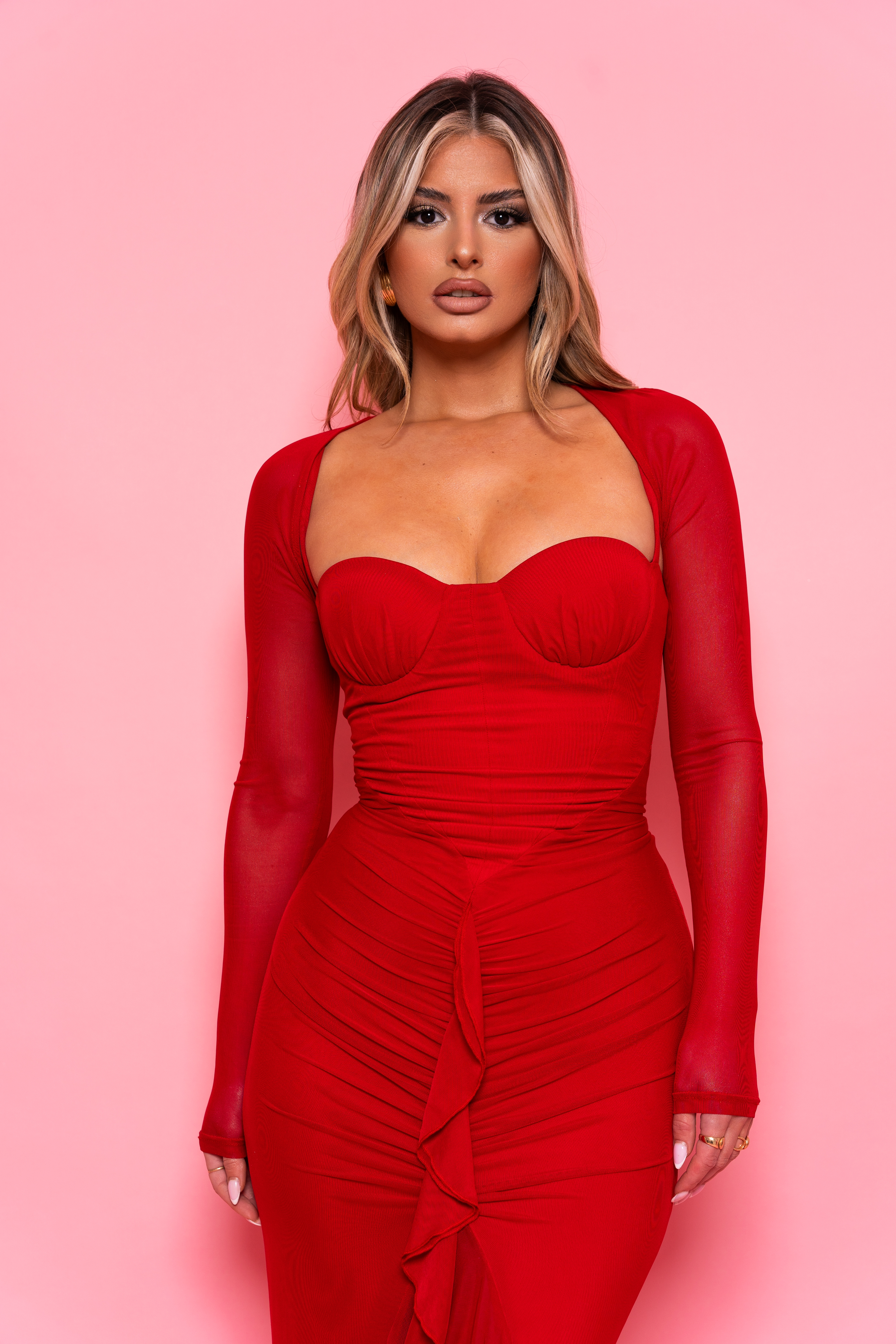 Sultry red gown with a sweetheart neckline and form-fitting ruched silhouette.