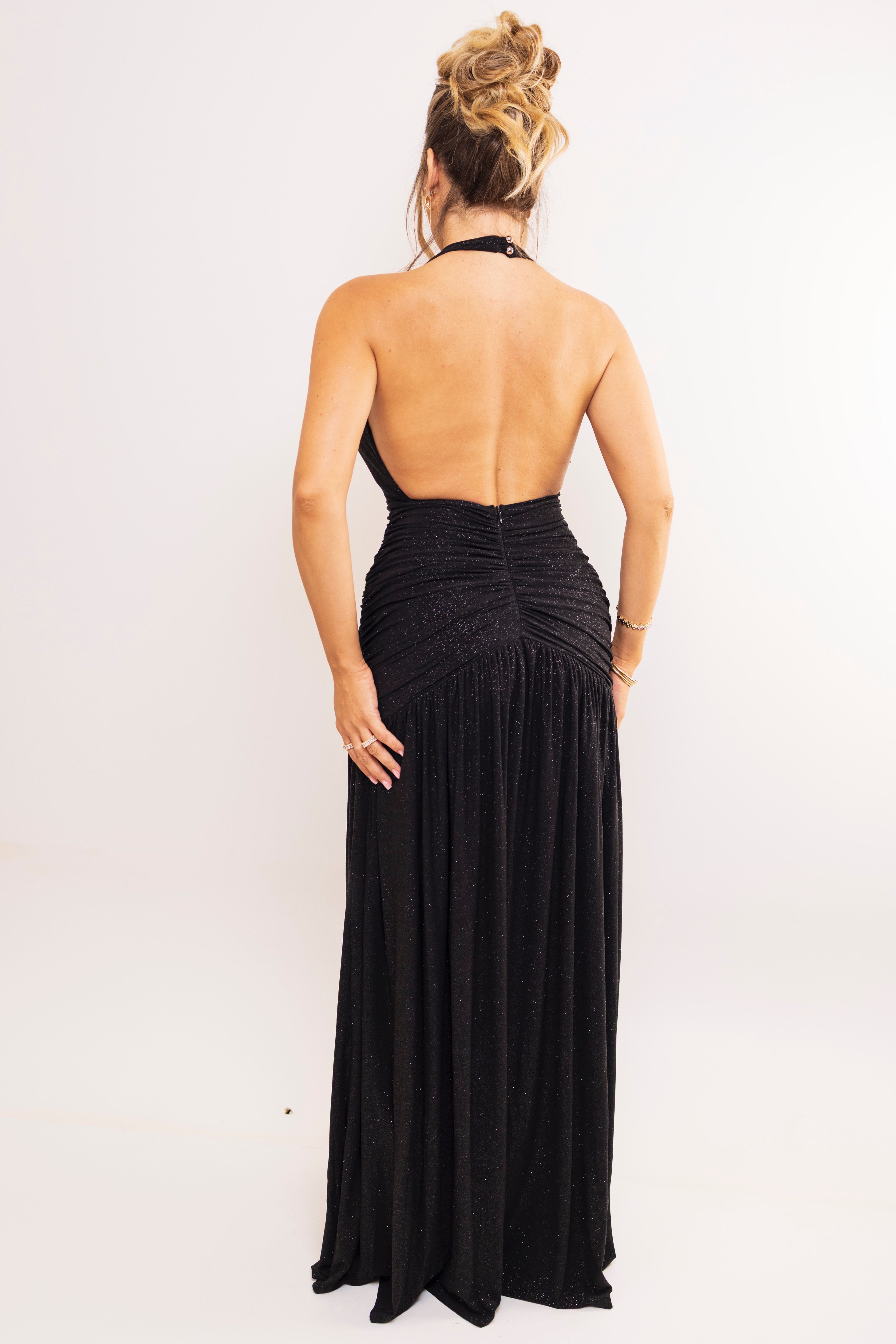 Elegant black gown with soft shimmer and open back design.