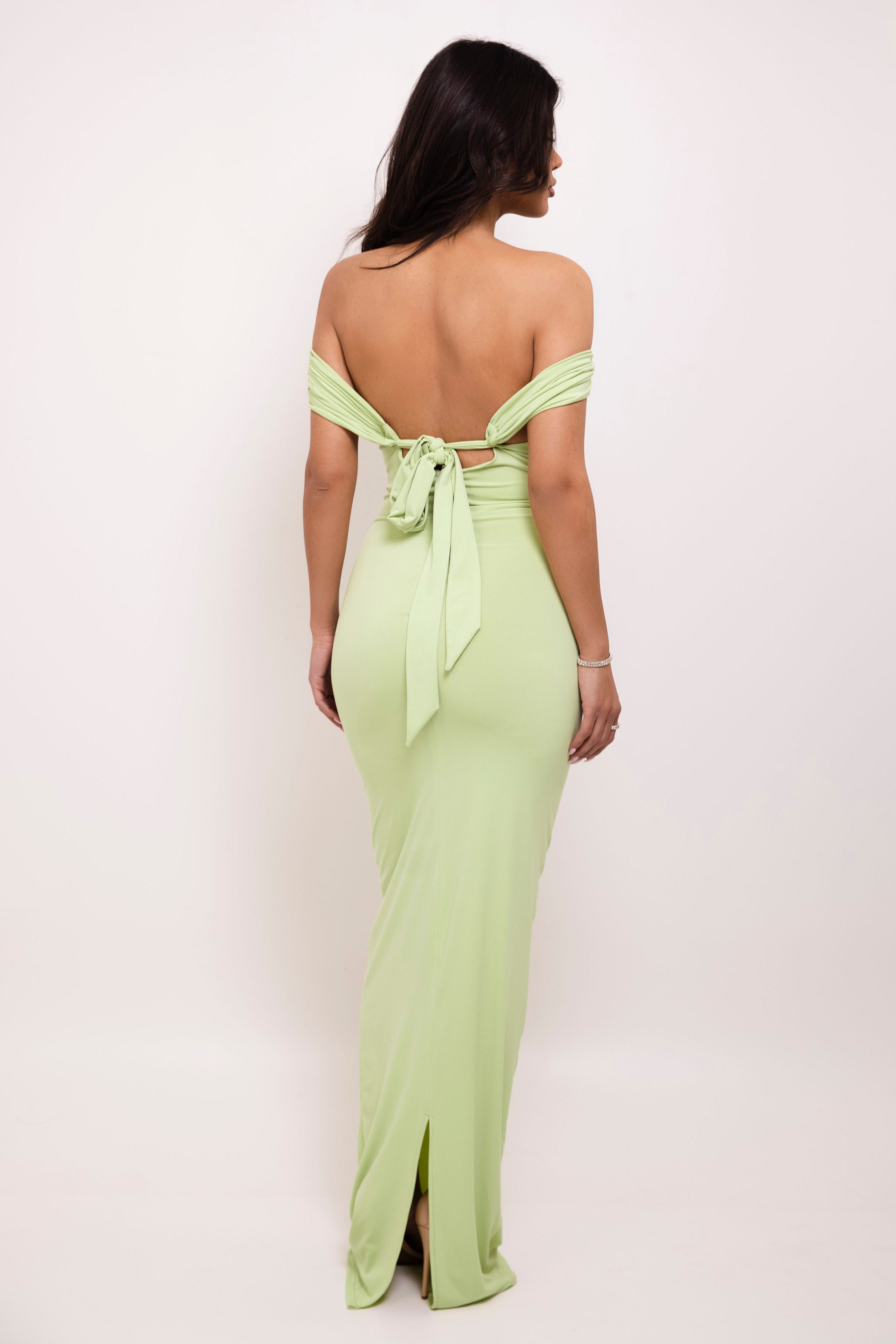 Slim-fit pastel green evening dress accented with a beautiful bow detail at the back.