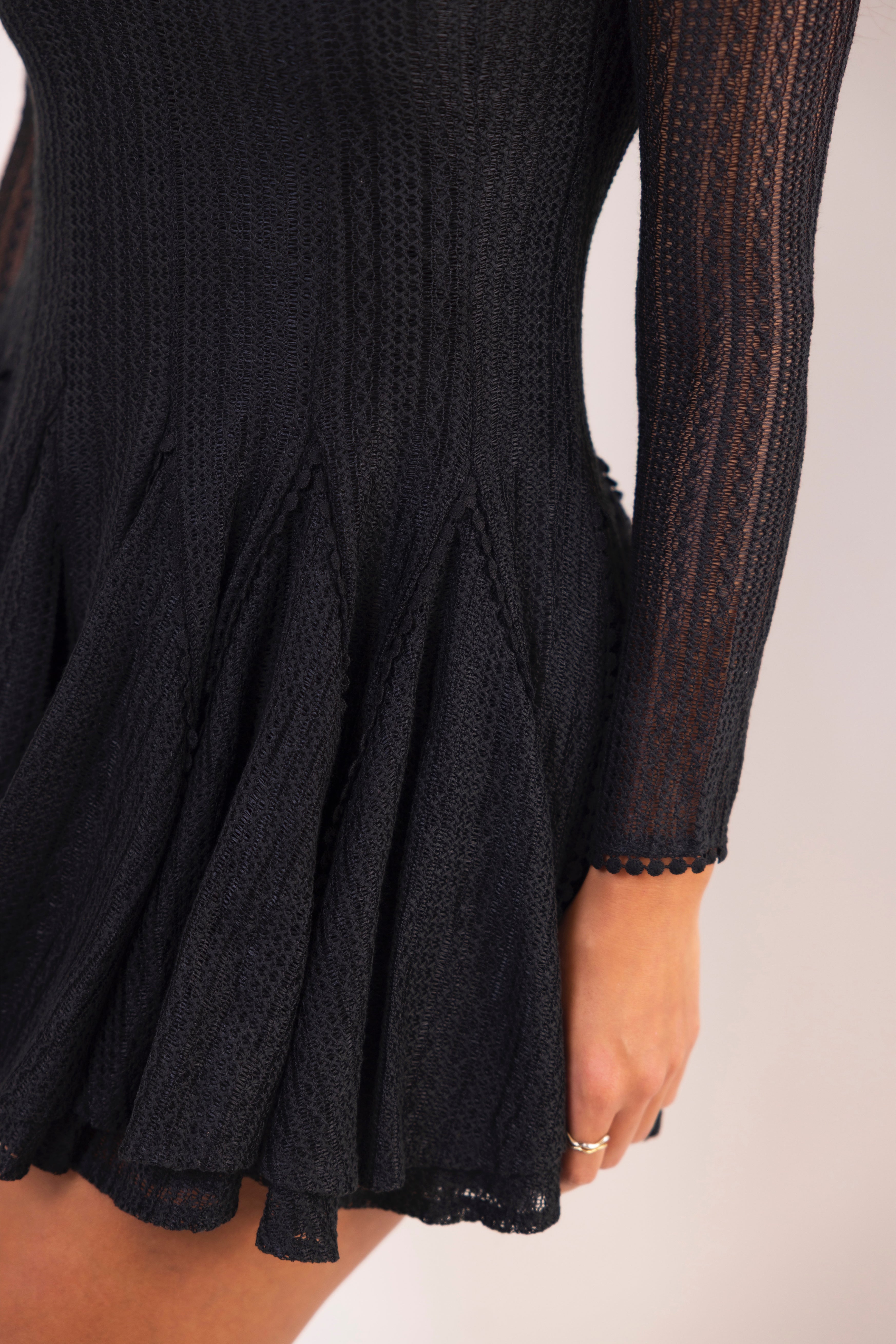 Black knitted dress with long sleeves on a white background