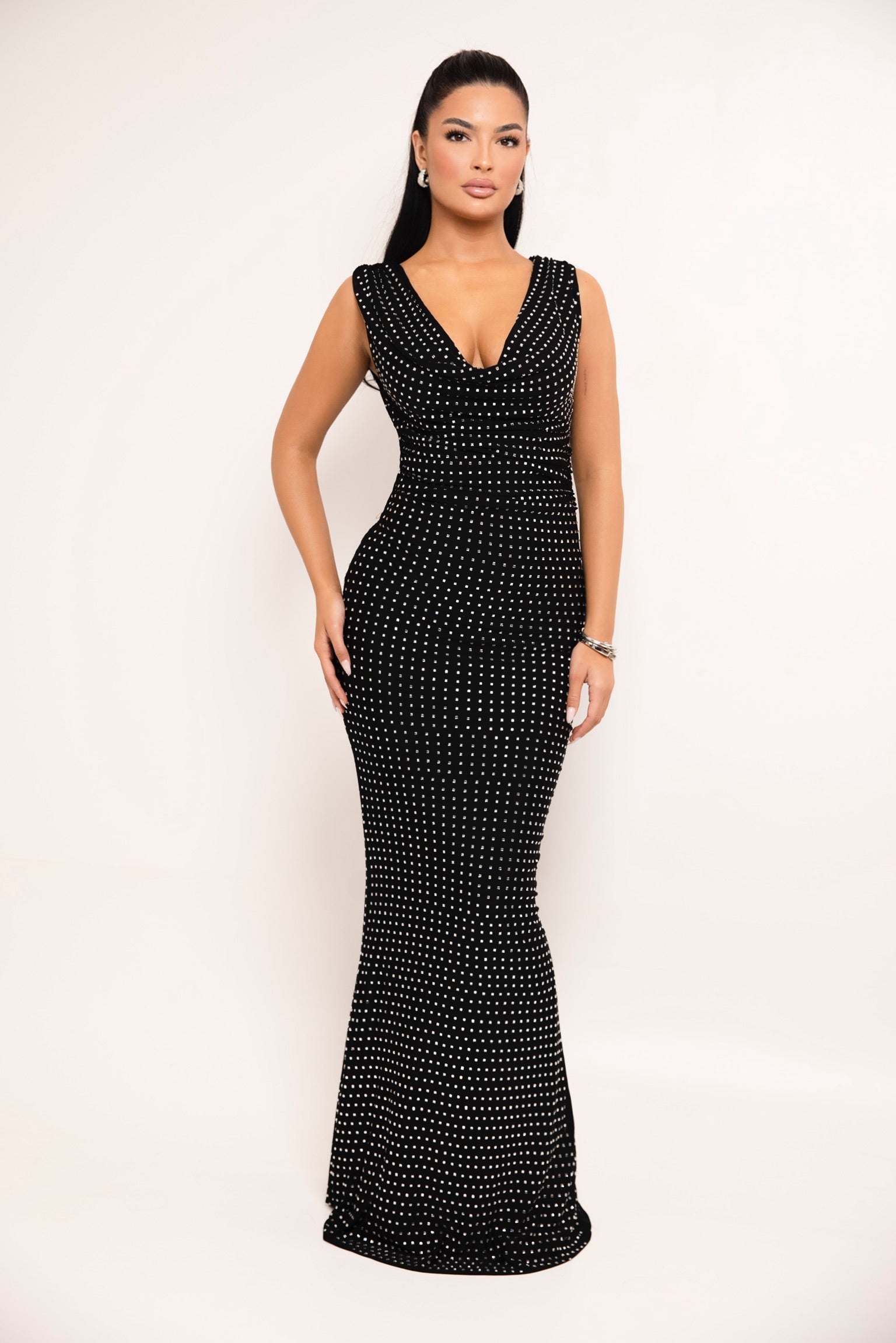 Black studded gown with deep V-neckline and body-hugging fit.