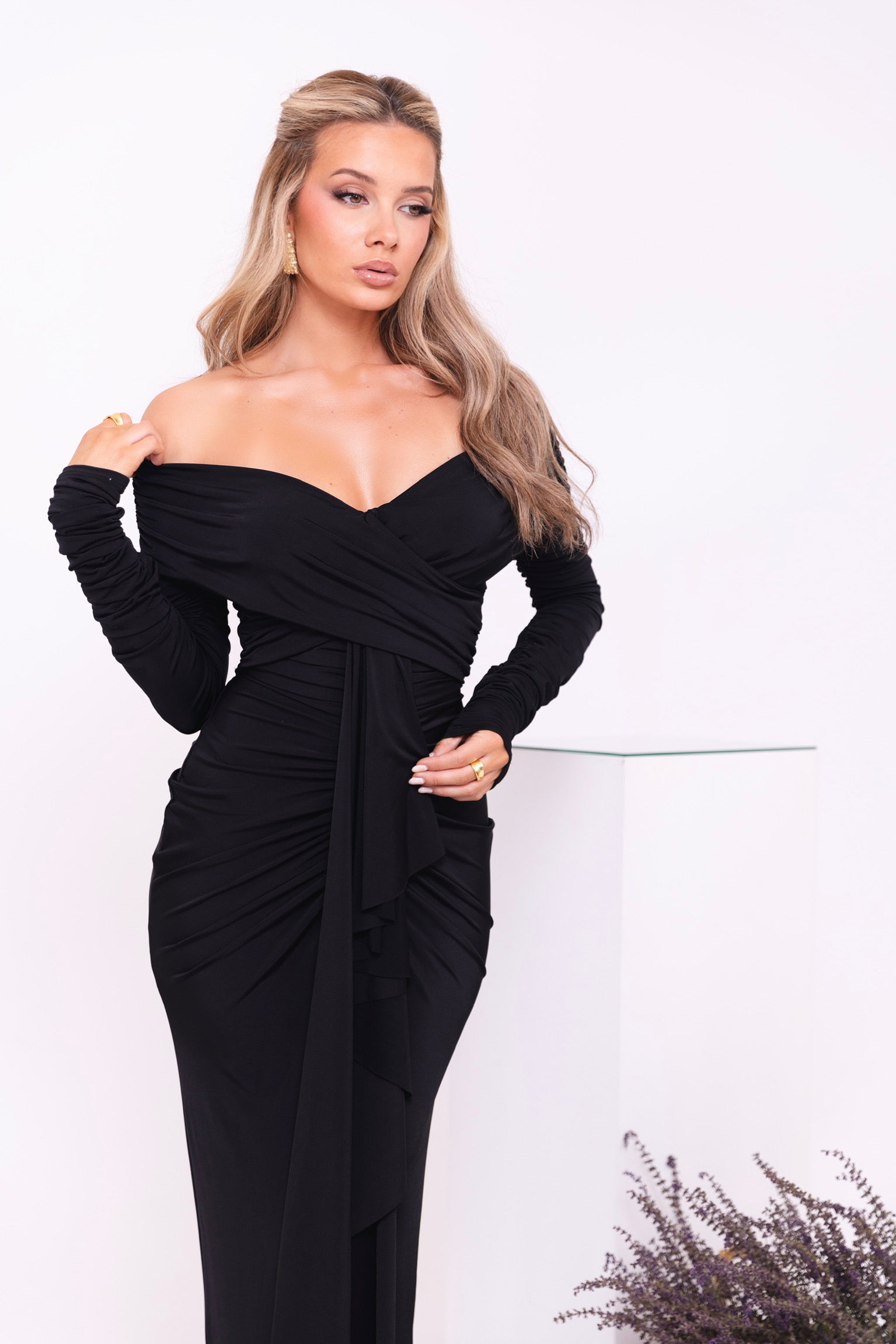 Timeless black dress with a structured, ruched waist, long sleeves, and floor-length elegance.