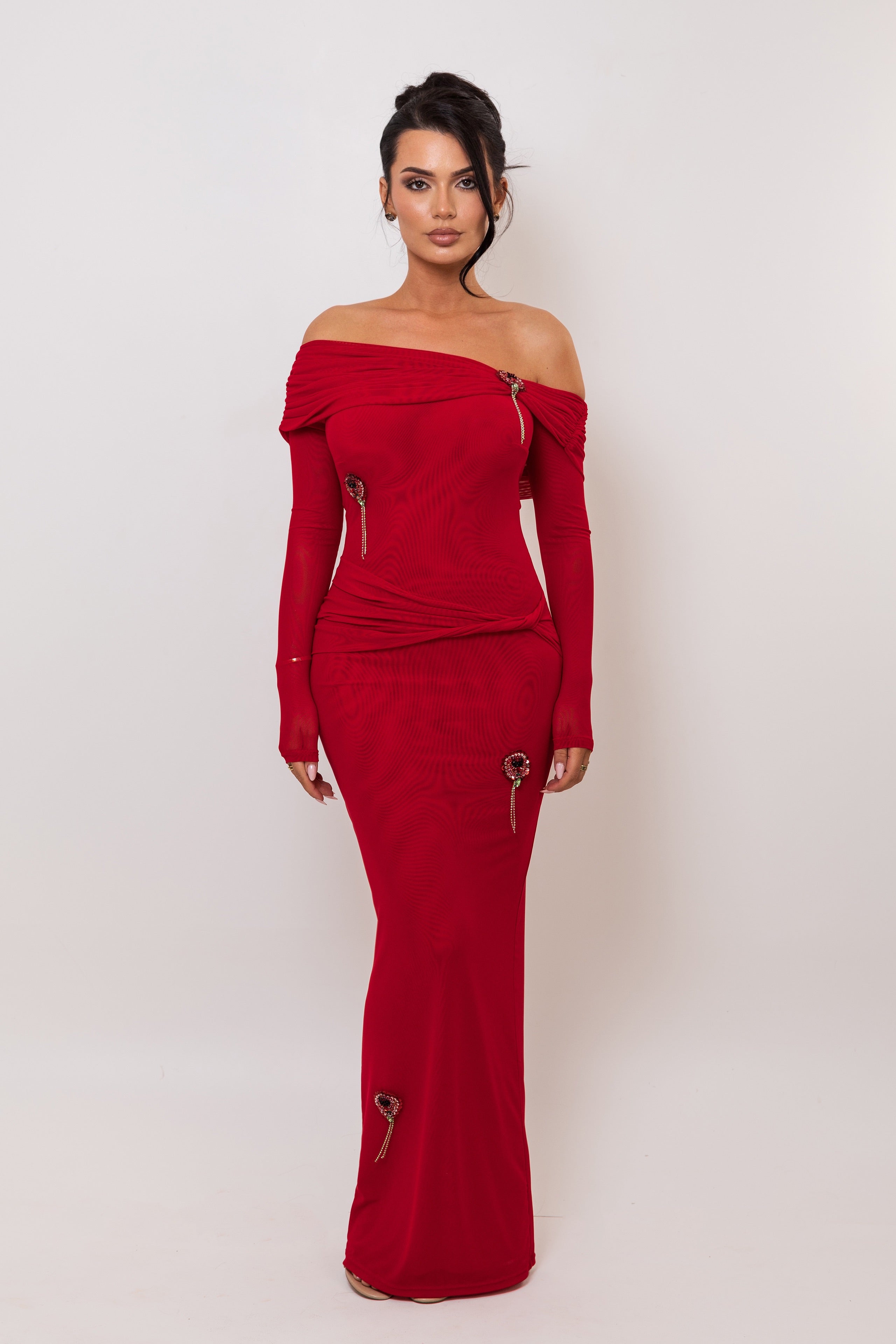Woman wearing a red off-shoulder dress with zippers on a white background