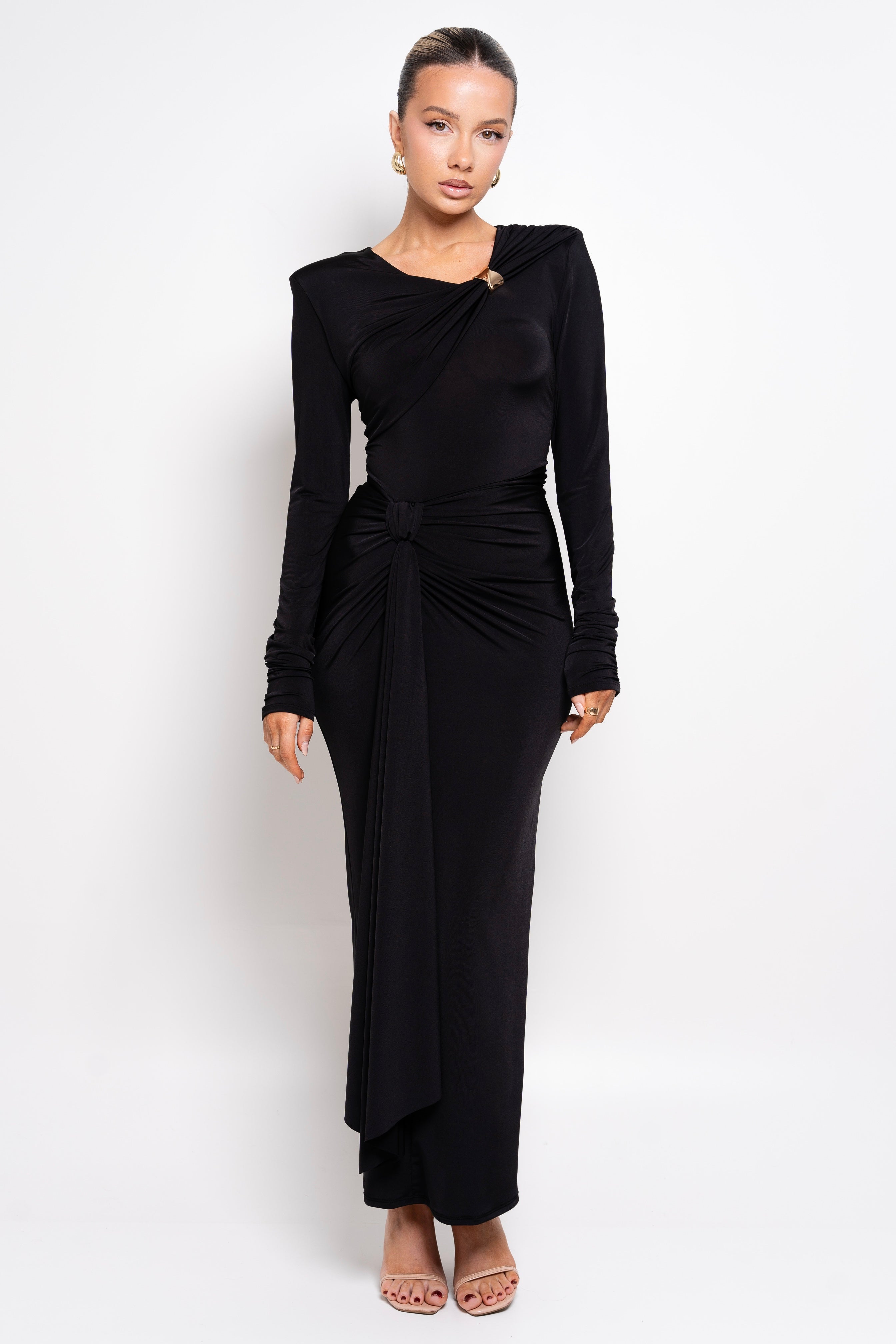 Model wearing a black one-shoulder dress with a knotted waist detail.