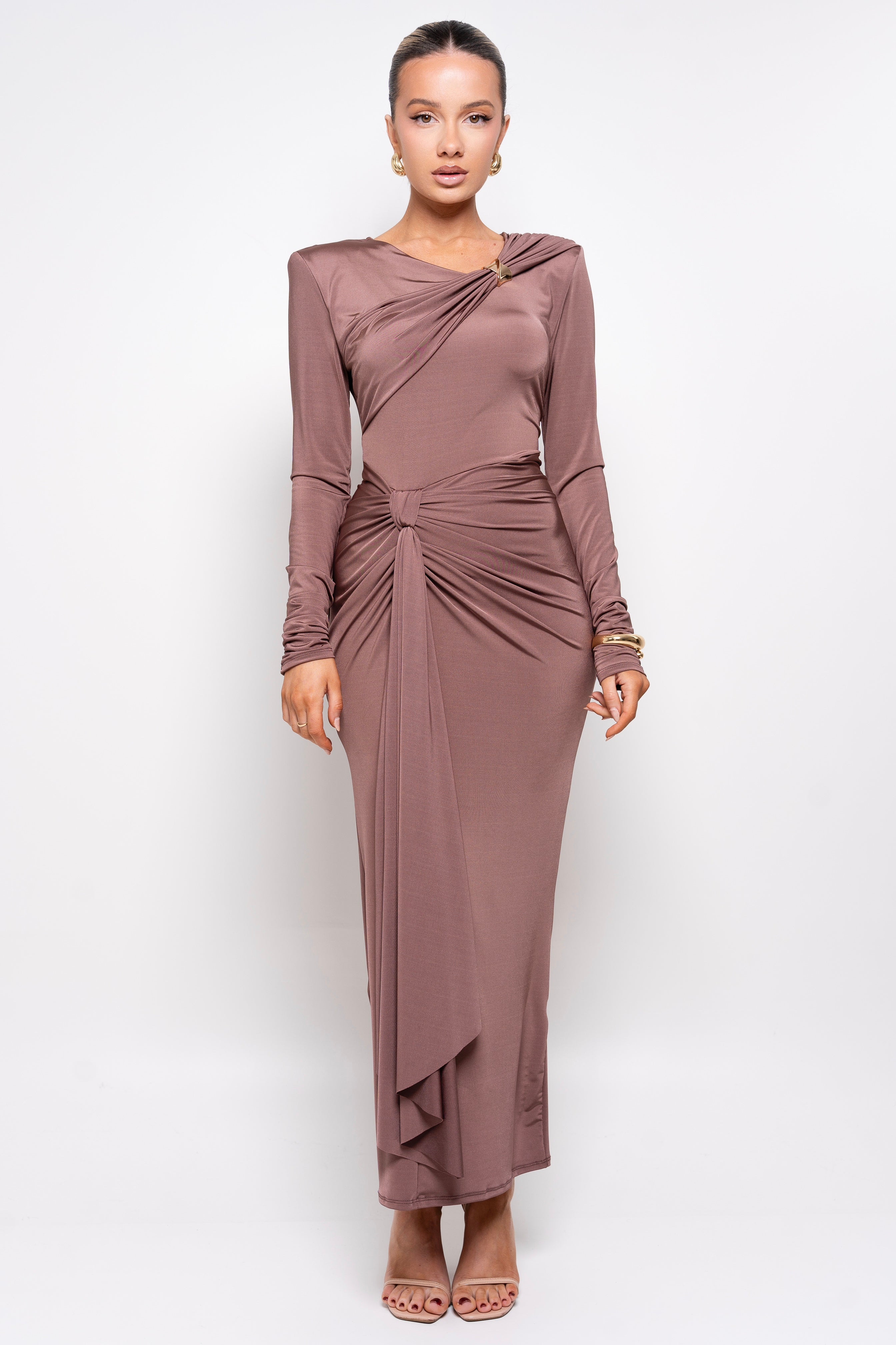 Model in a stylish brown dress with a knotted waist and gold clasp detail.