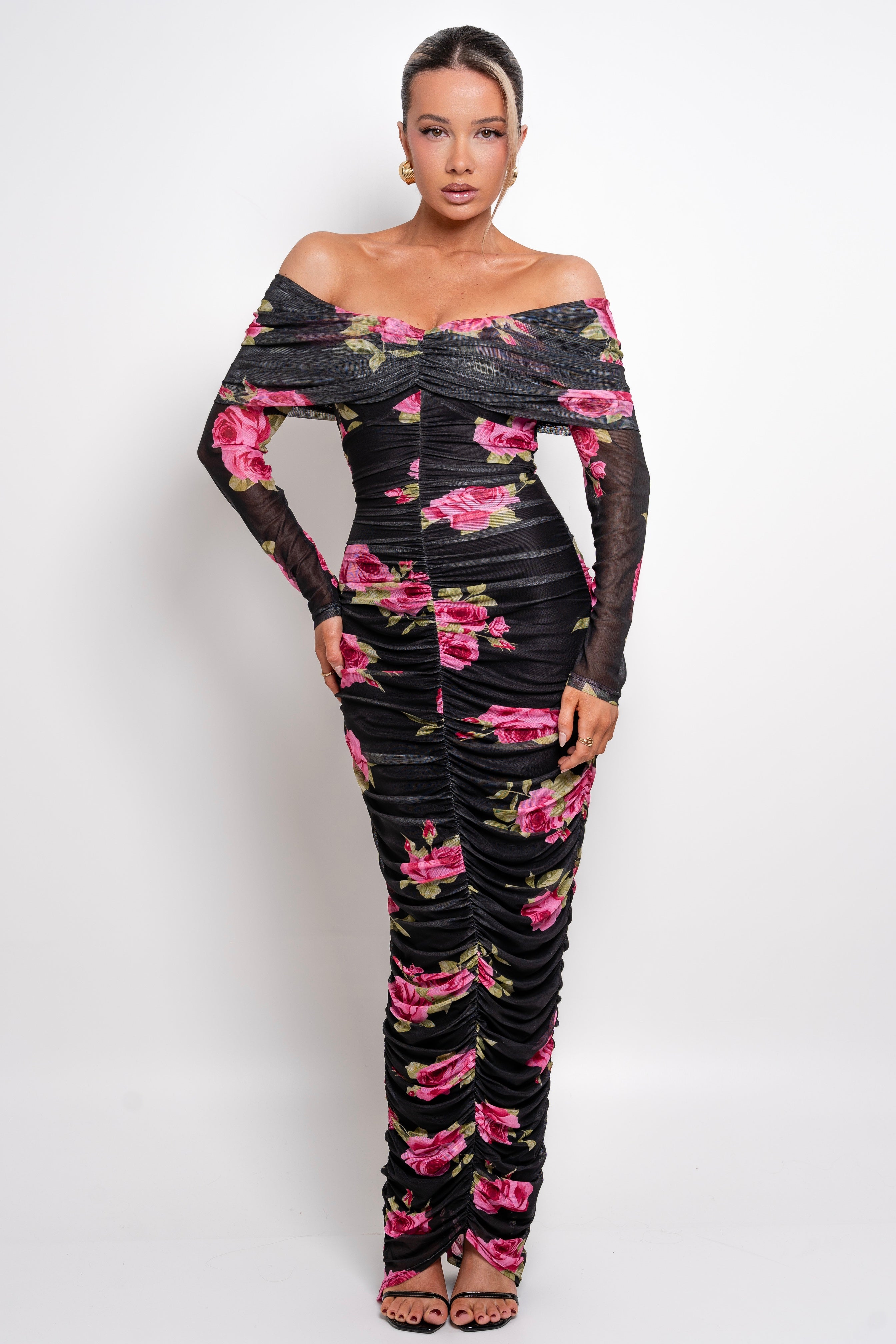 Stunning off-the-shoulder black dress with vibrant pink floral print and ruched detailing.