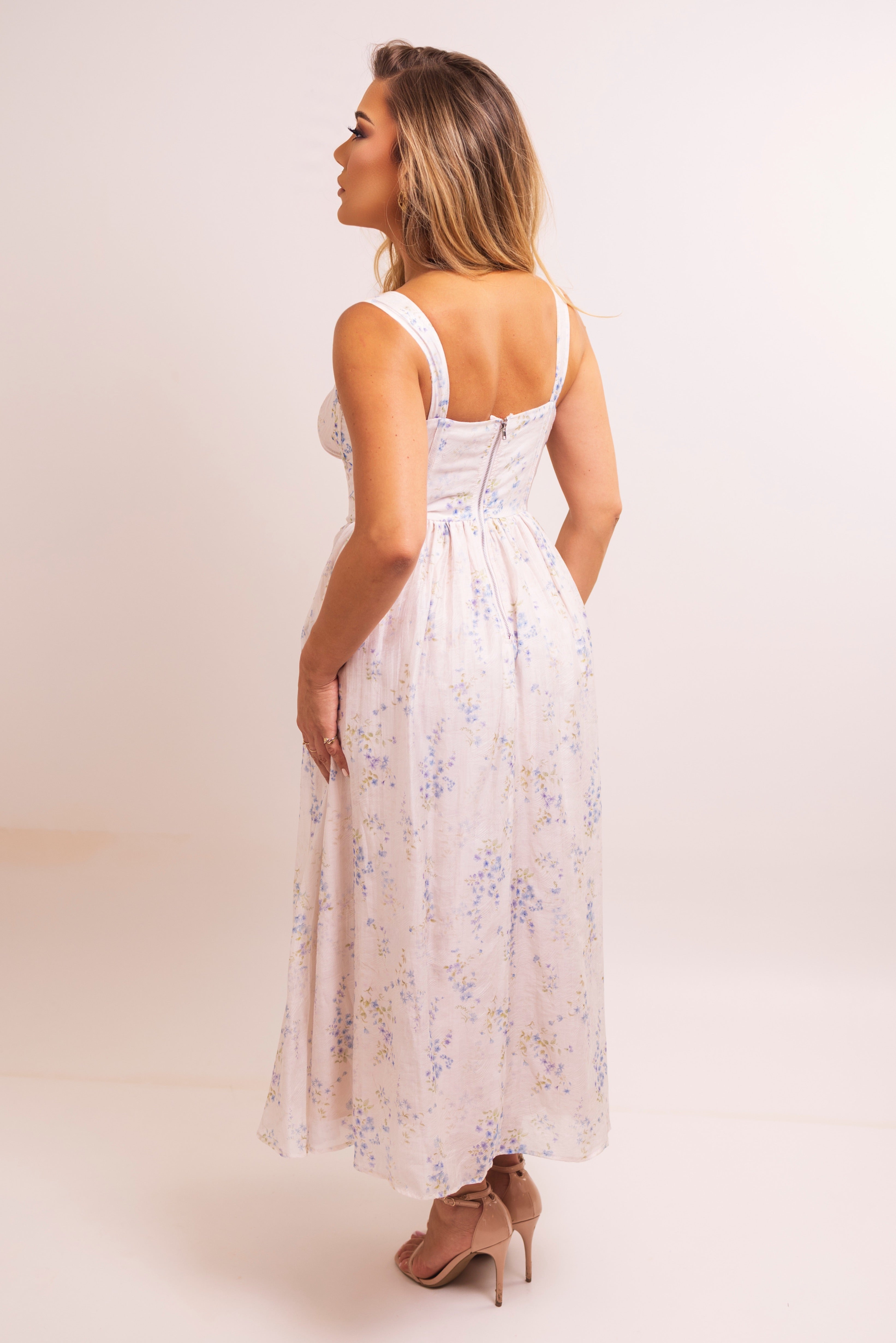 Back view of a model in a floral dress with a zipper closure.