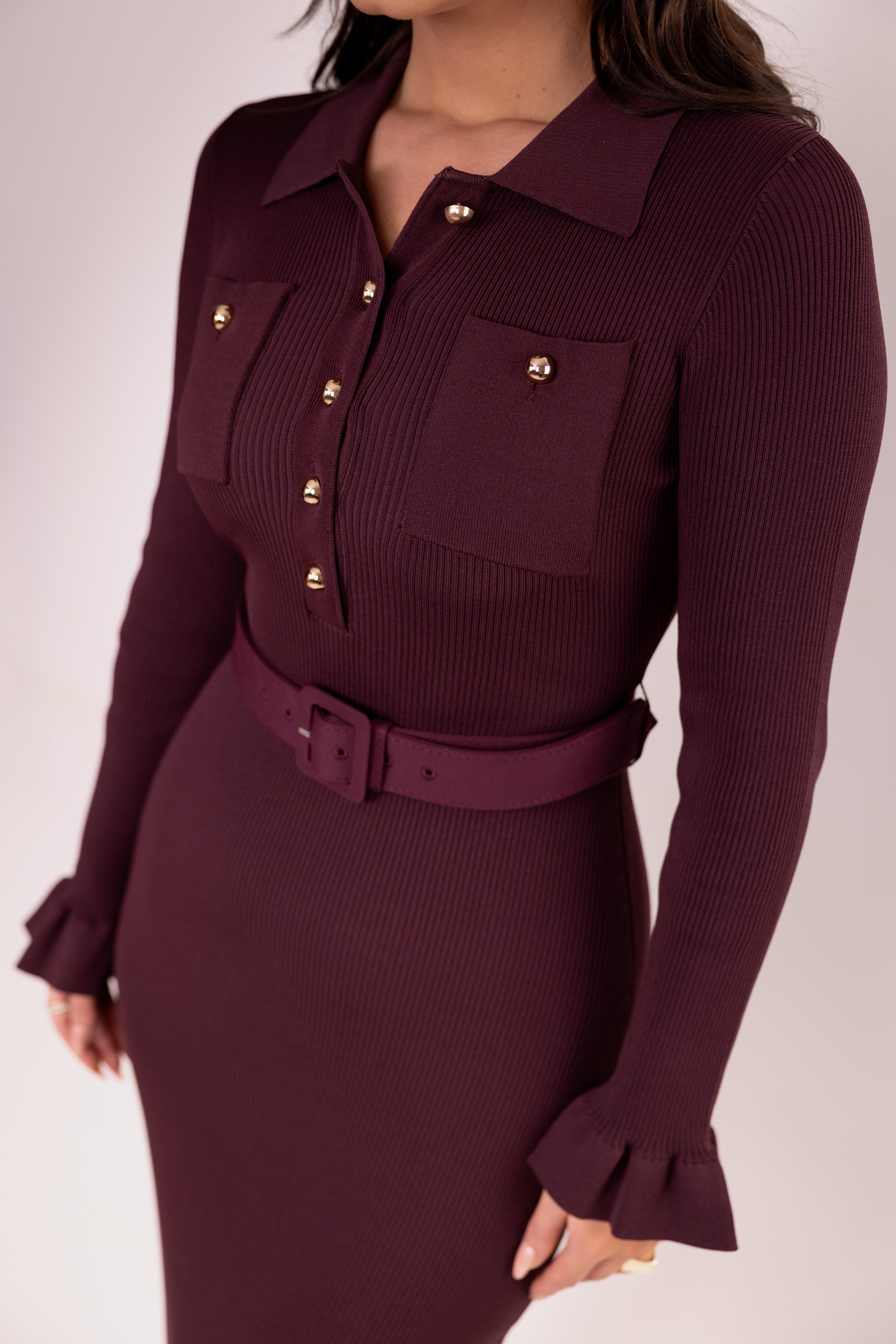 Maroon dress with gold buttons and belt on a white background
