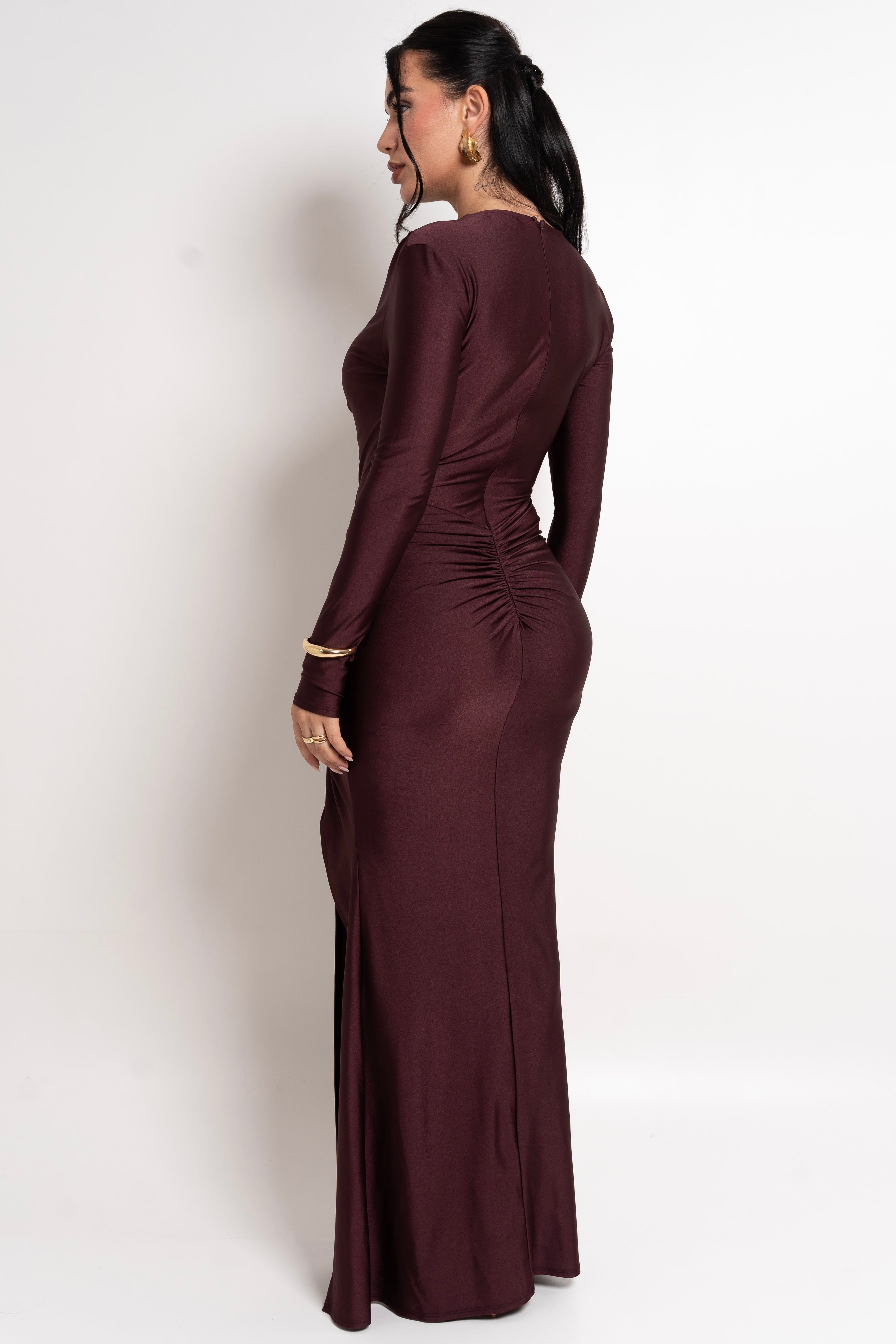 Sleek, figure-enhancing burgundy dress featuring a gathered slit detail.