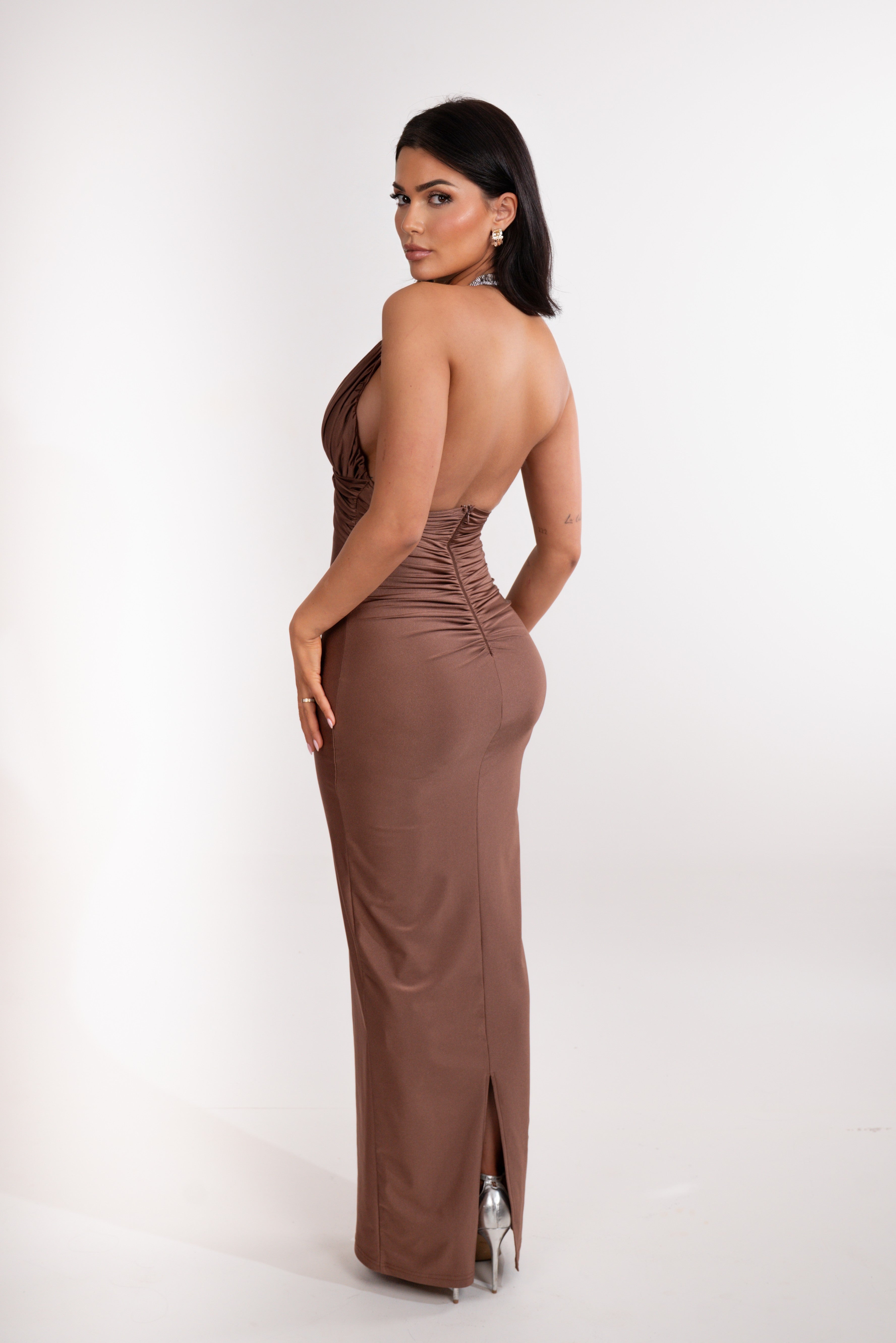 Woman wearing a brown halter neck gown on a white background