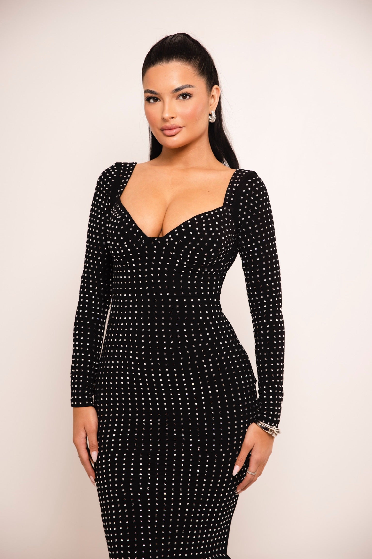 Formal long-sleeve black dress with shimmering embellishments.