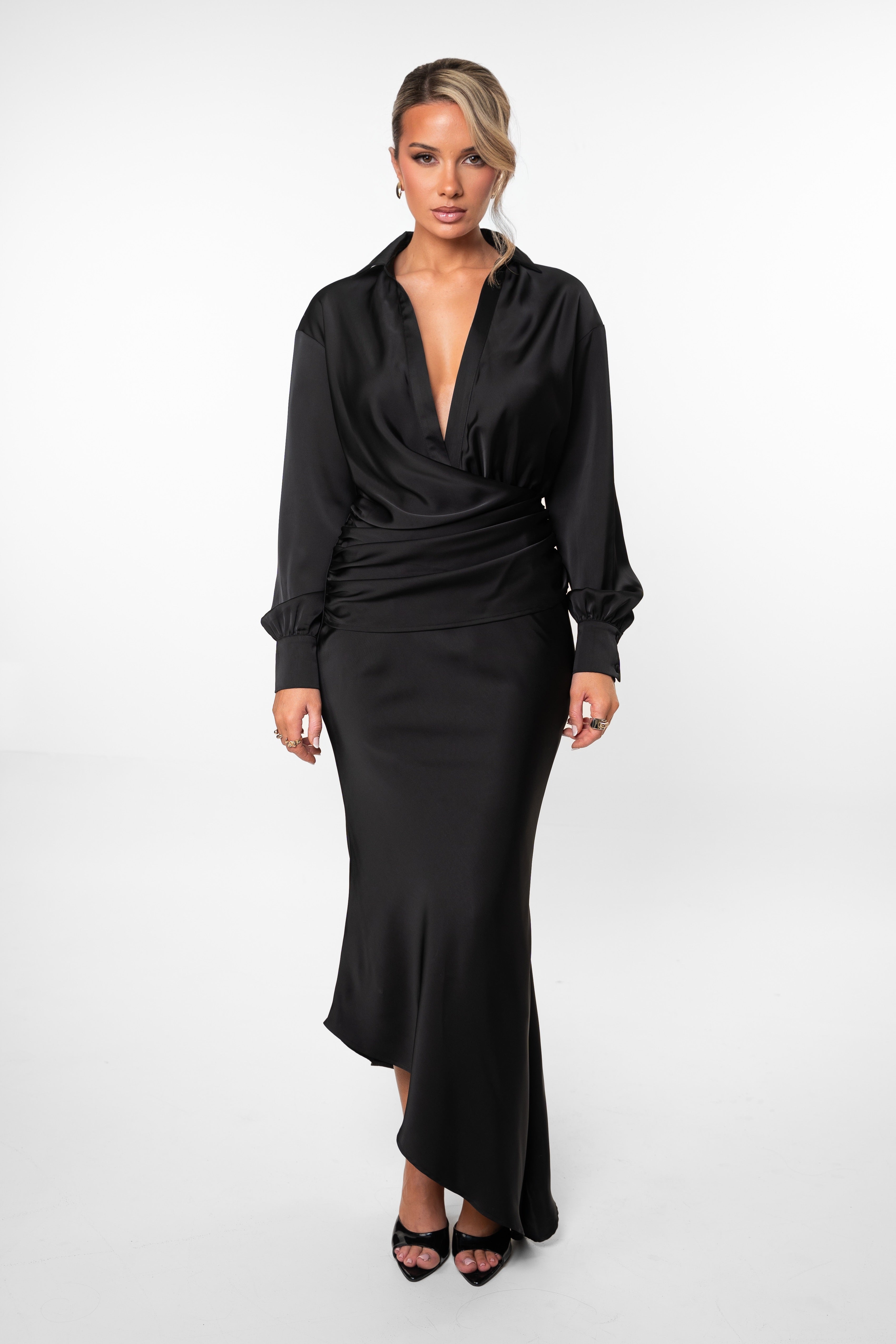 Woman wearing a black dress with a plunging neckline on a white background