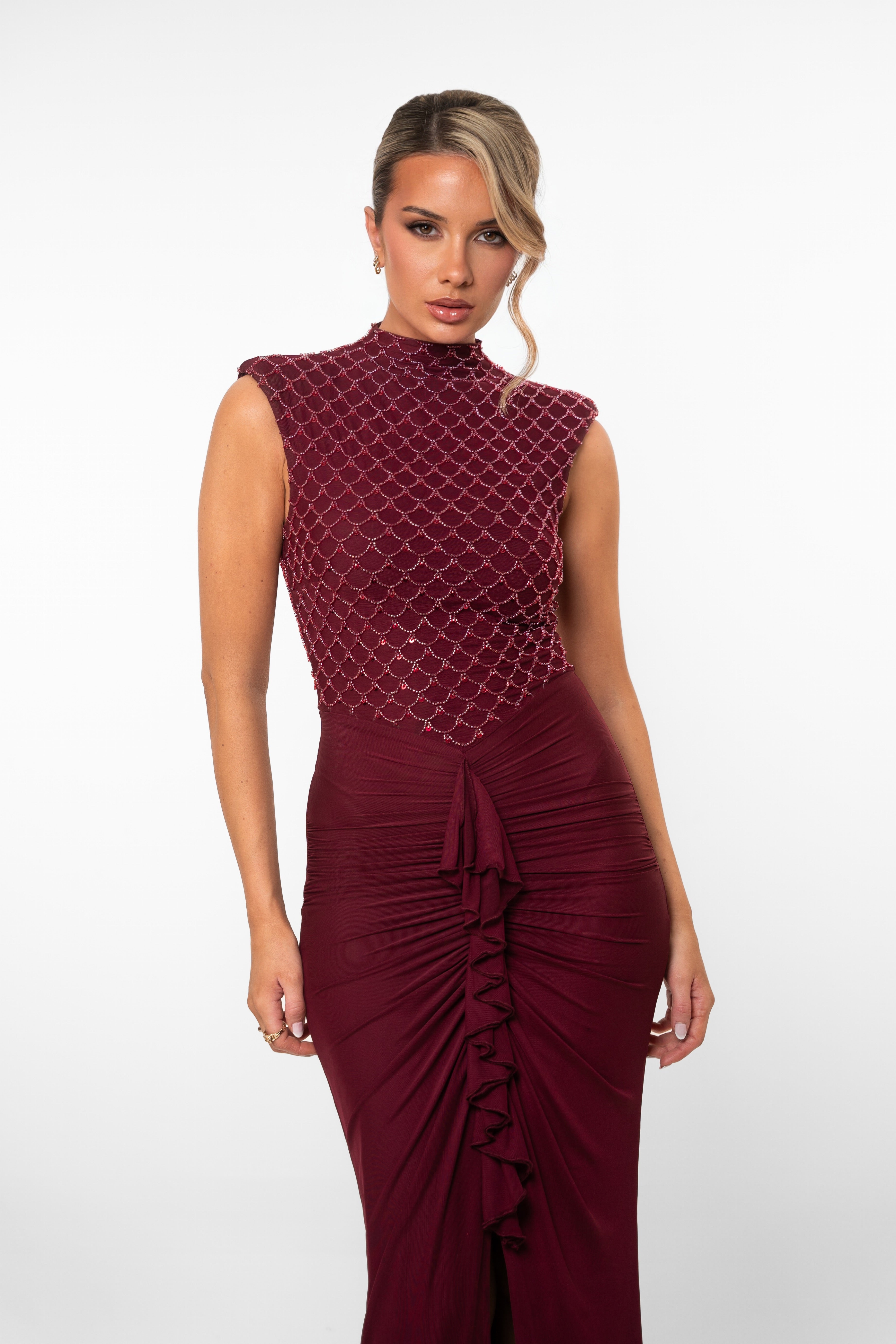 Fitted burgundy dress with scale-like beading on top and gathered ruffle down the skirt
