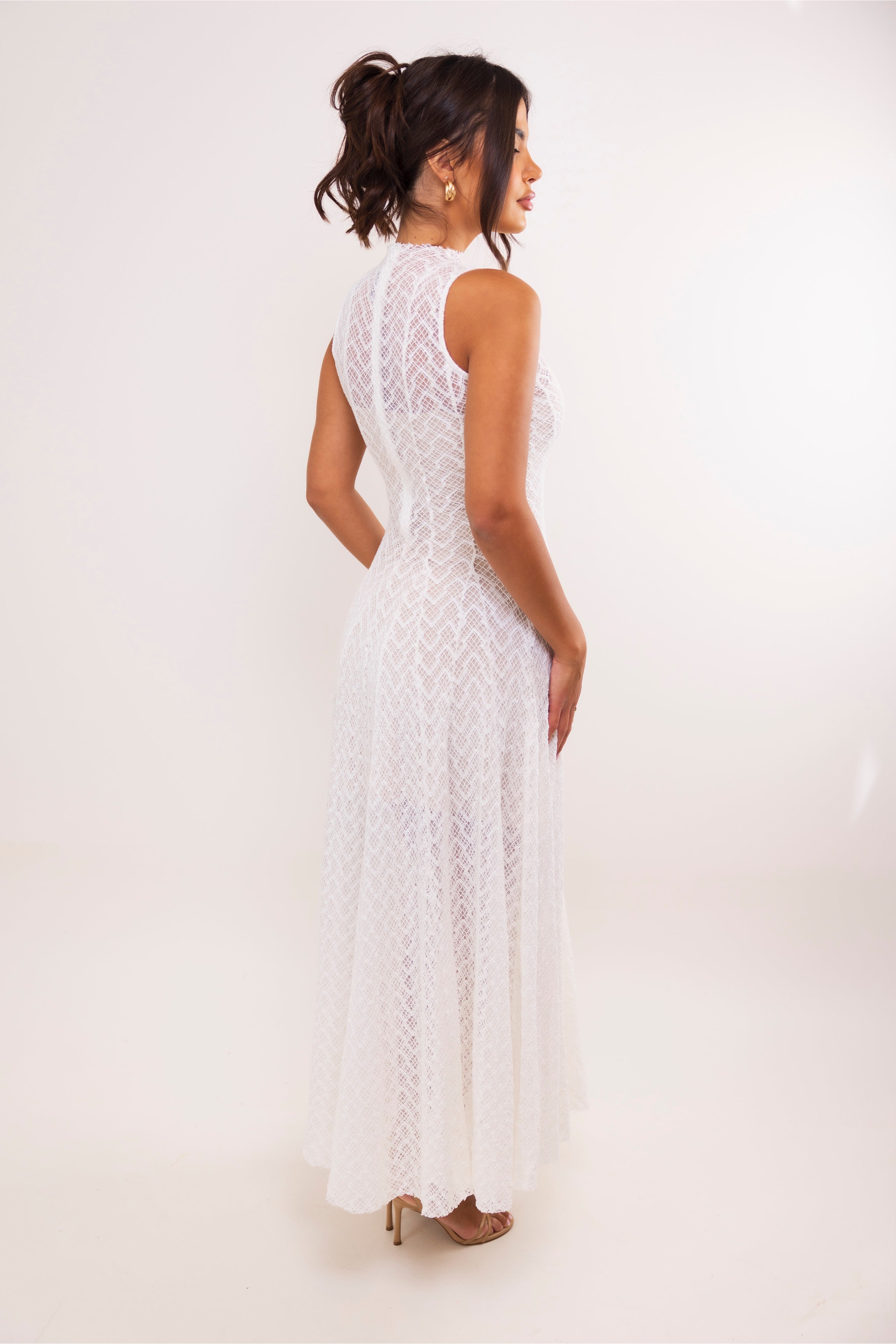 Back/side view of high-neck white lace dress with contour seams and flowing hem