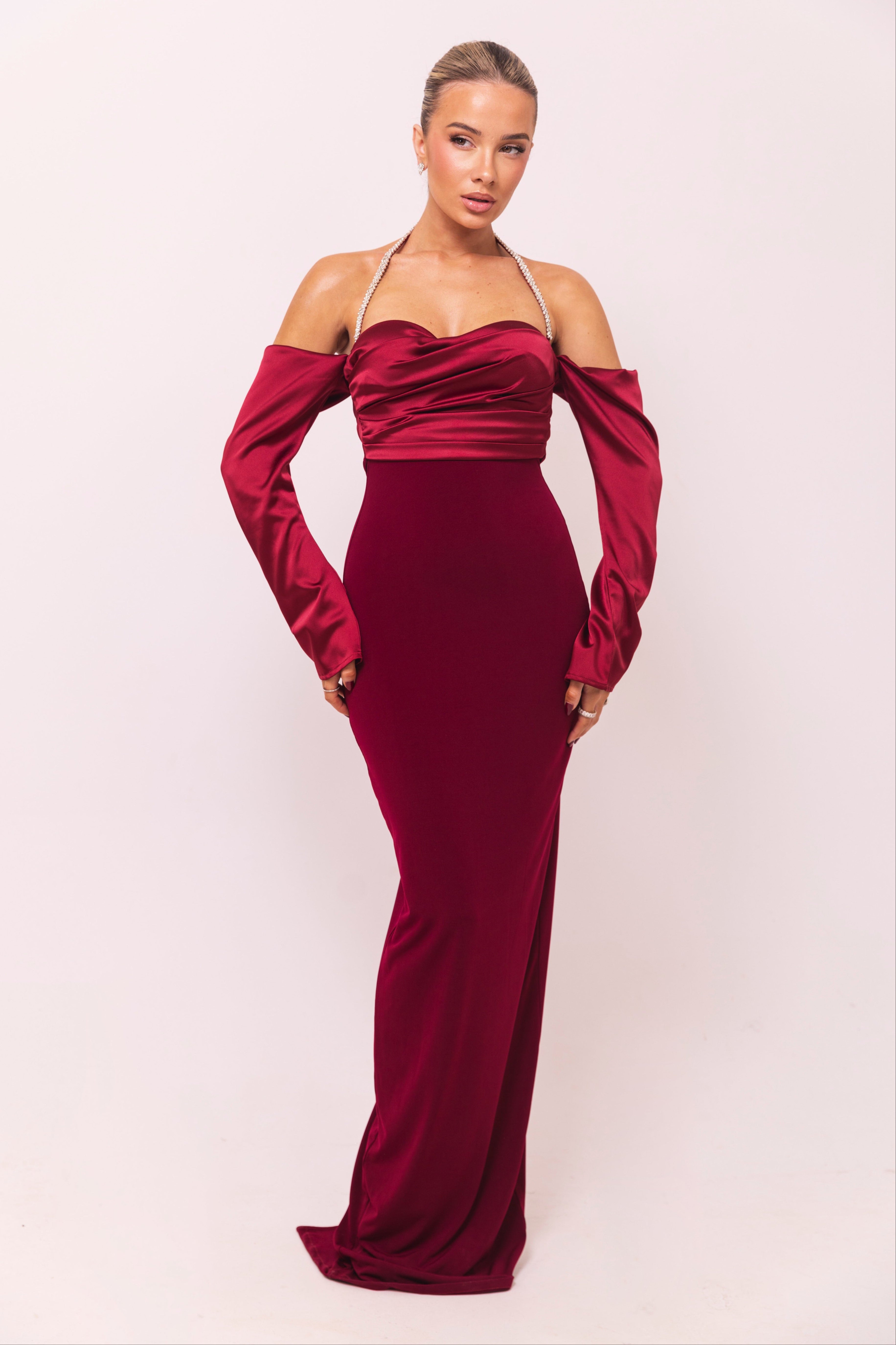 Sophisticated burgundy evening gown featuring a draped satin design and fitted silhouette.