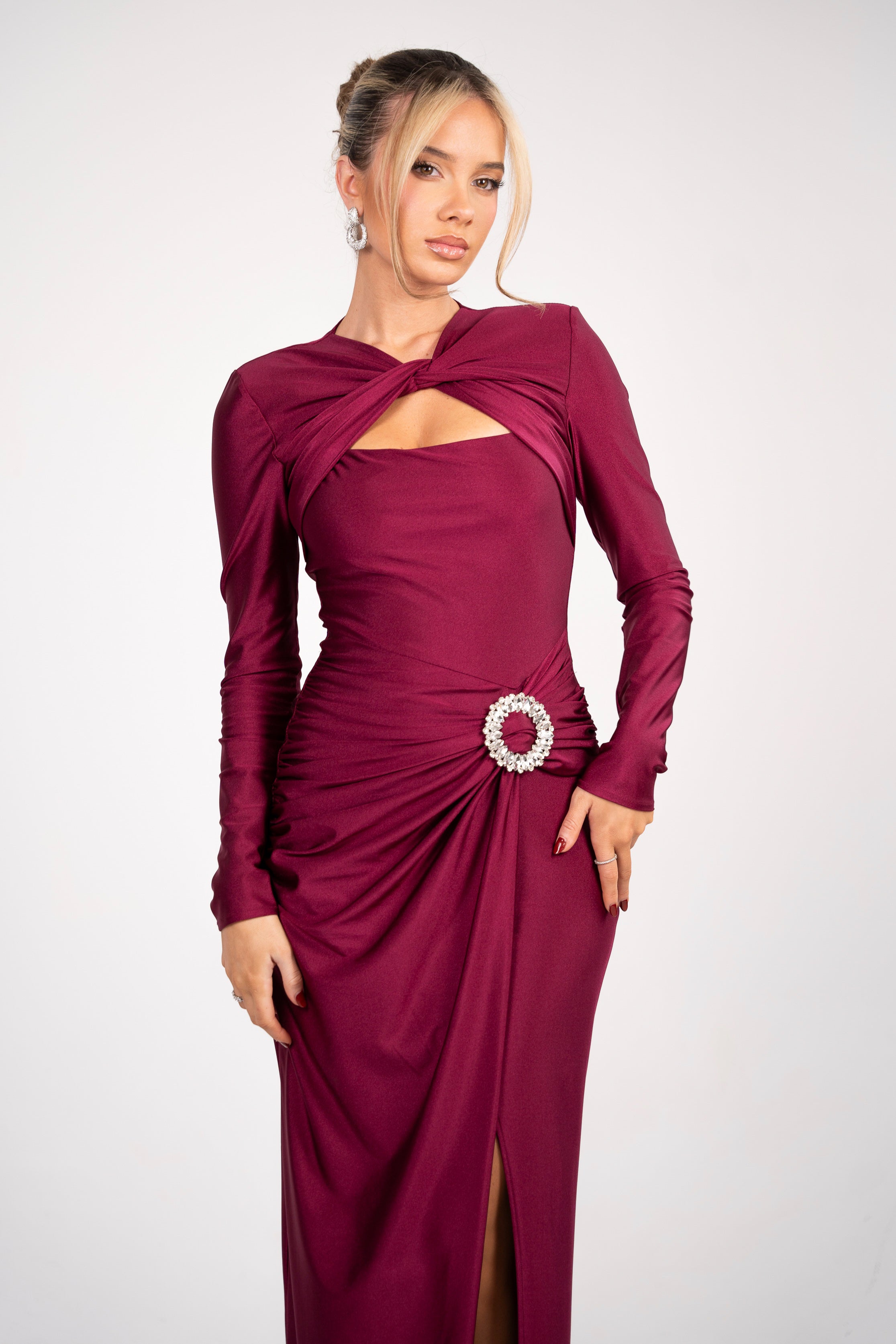 Stylish formal gown in wine-red with a ruched waist, long sleeves, and a sparkling brooch detail