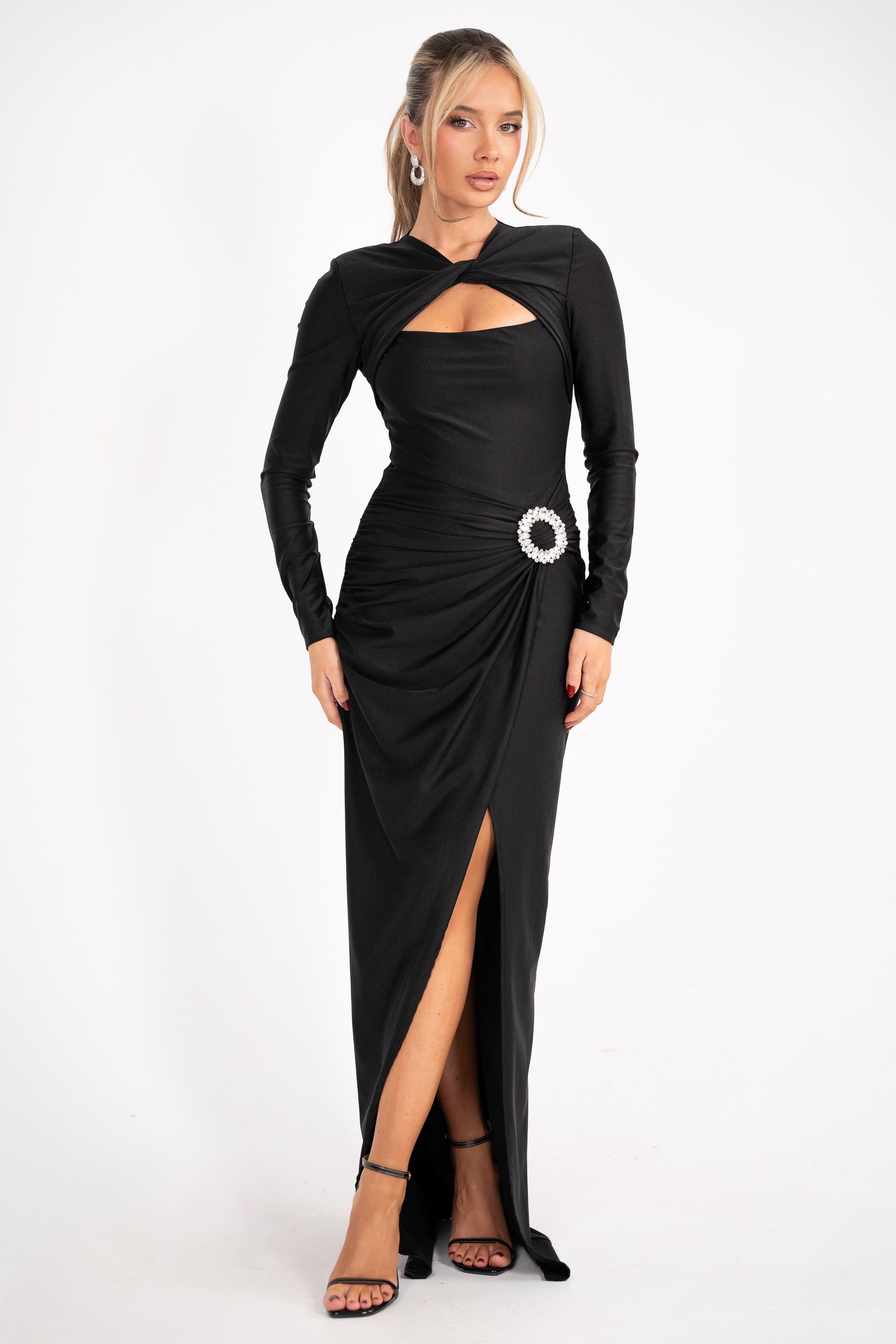 Elegant black gown featuring long sleeves and a jeweled detail