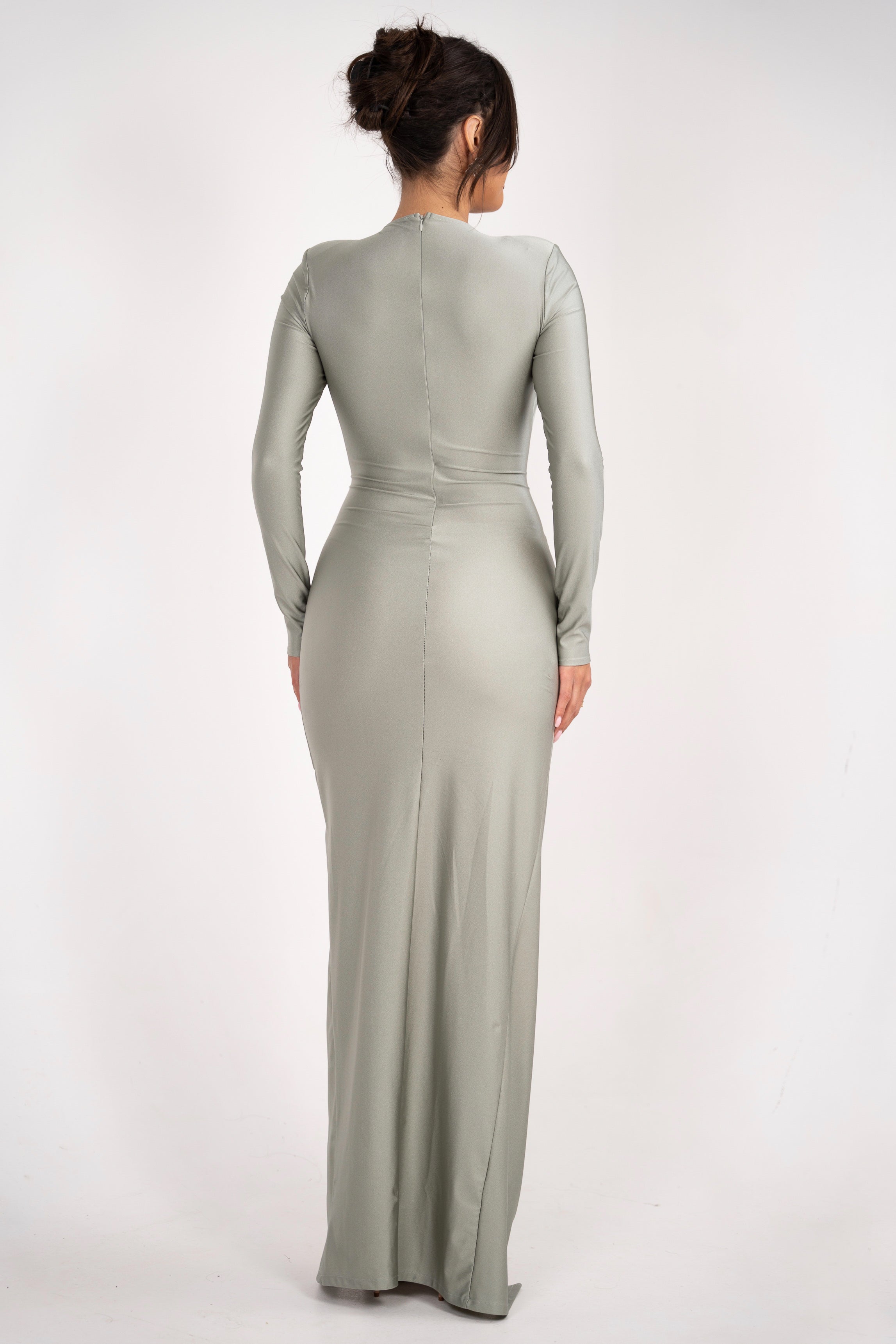 A muted sage dress with a refined silhouette, complete with a ruched waist and an ornate brooch detail