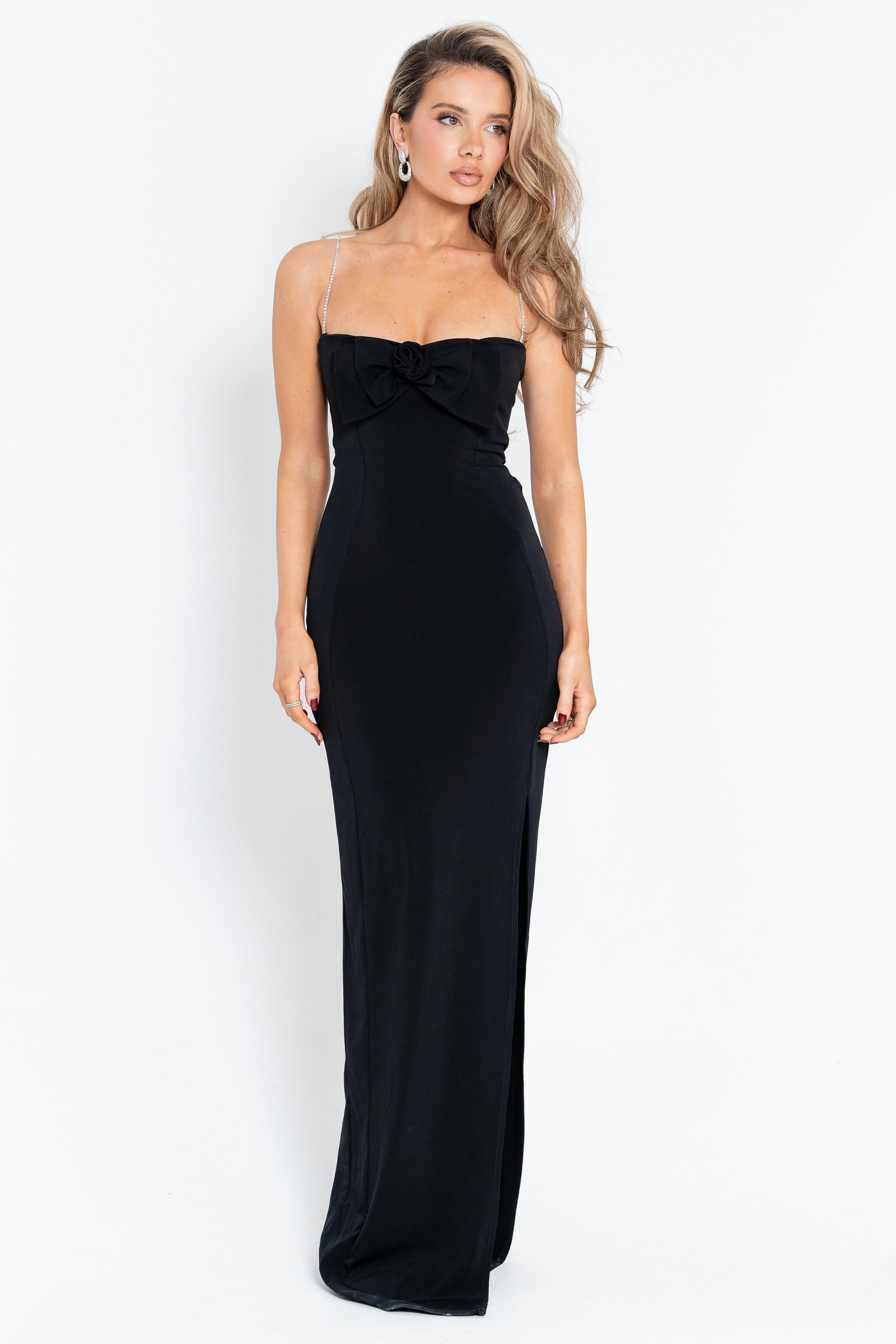 Elegant black dress adorned with a bow and rose accent, exuding charm and timeless sophistication.