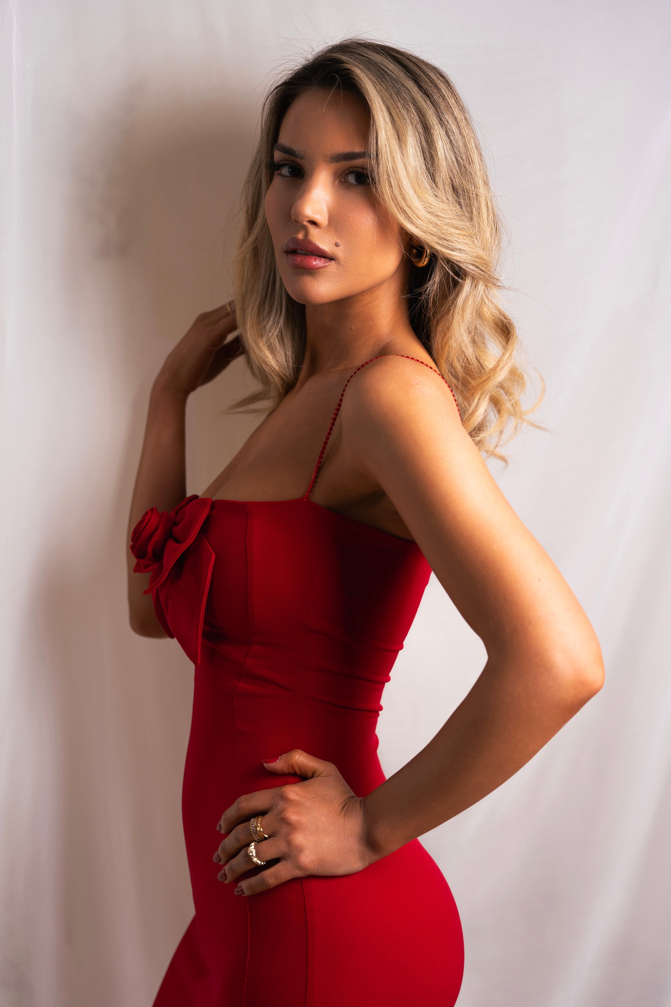 Vibrant red evening gown featuring a bow detail and a high slit, perfect for making a statement.