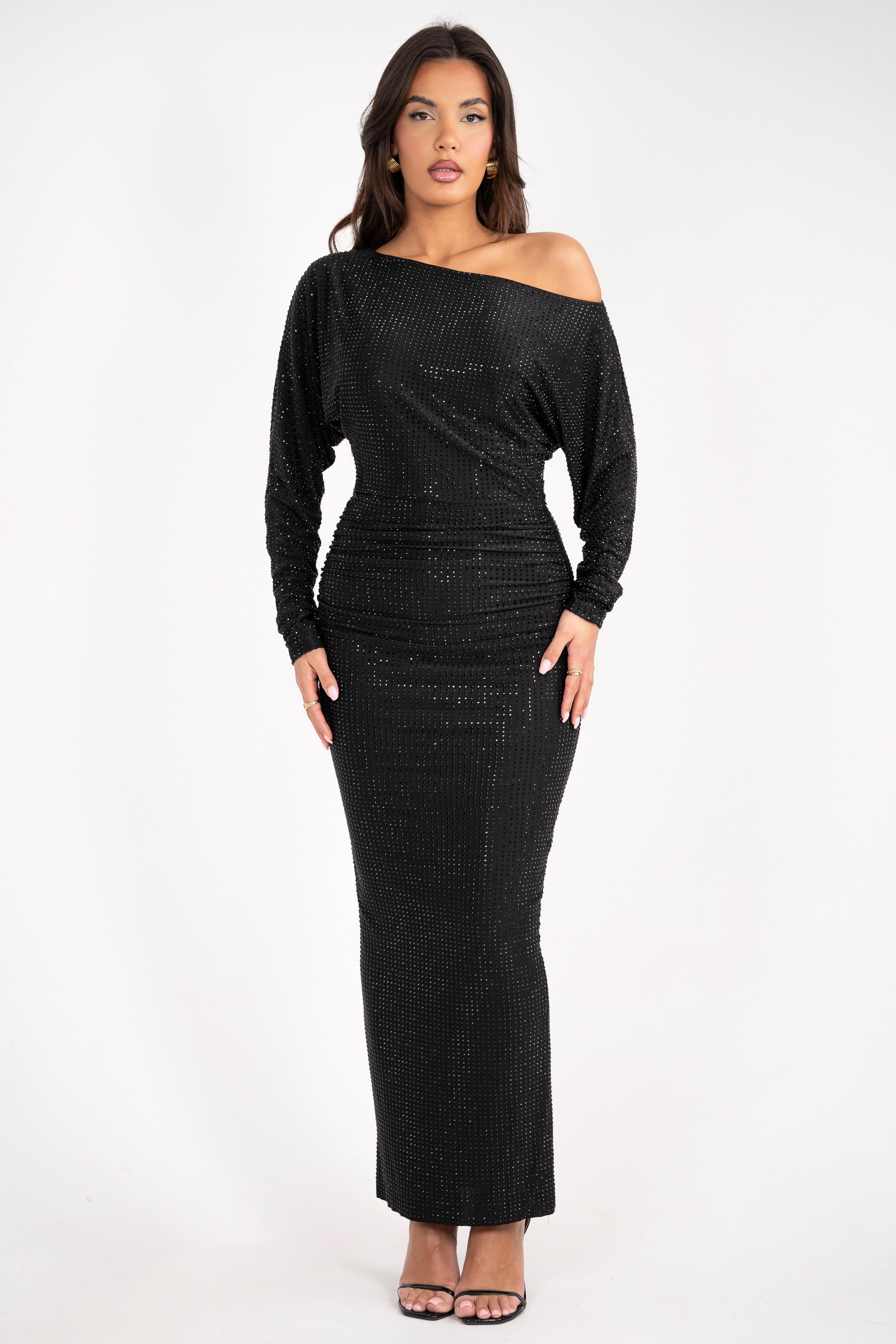 Sparkling black gown featuring a single bare shoulder and long sleeves