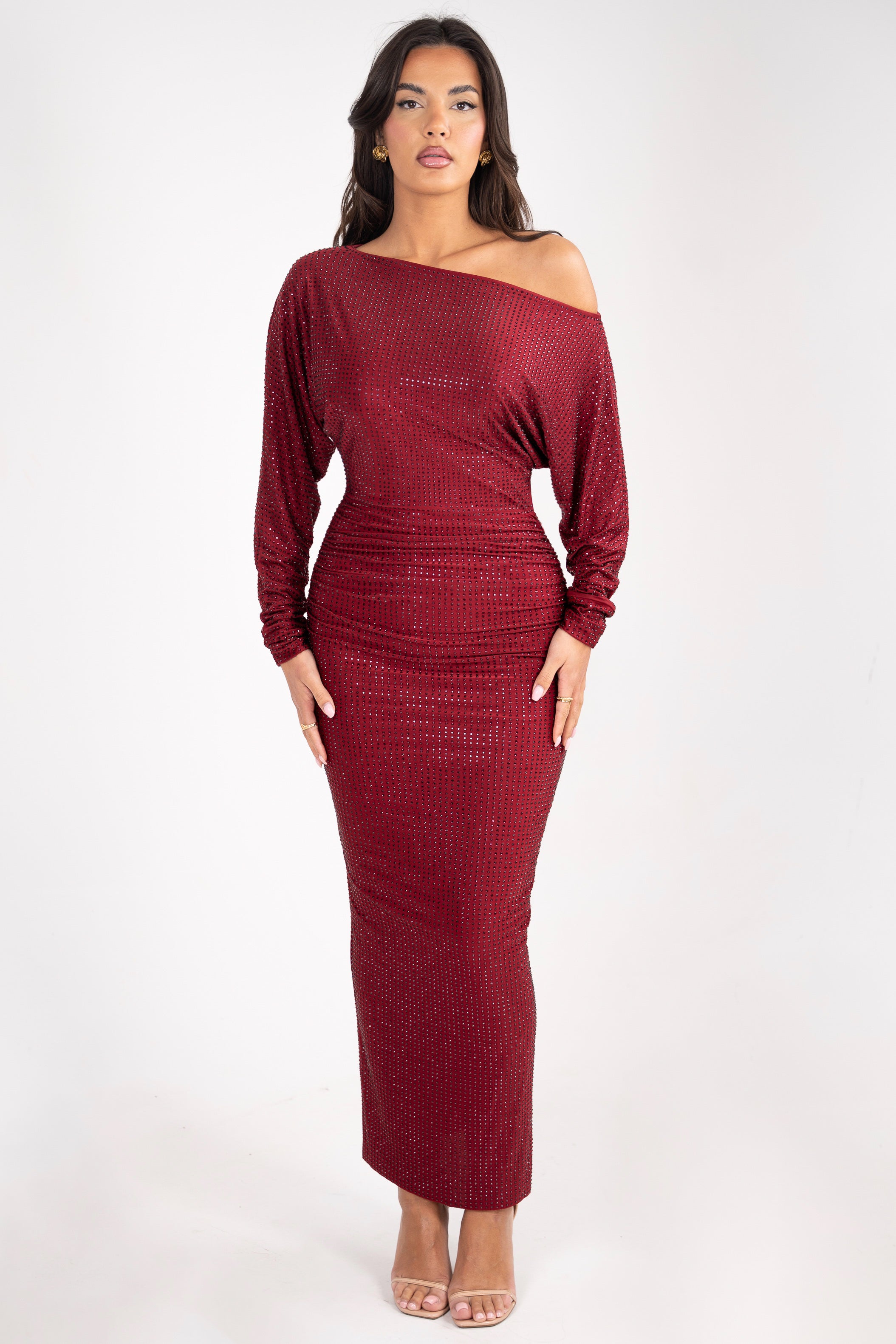 Model wearing a burgundy dress adorned with rhinestone details, featuring a sparkling and glamorous design