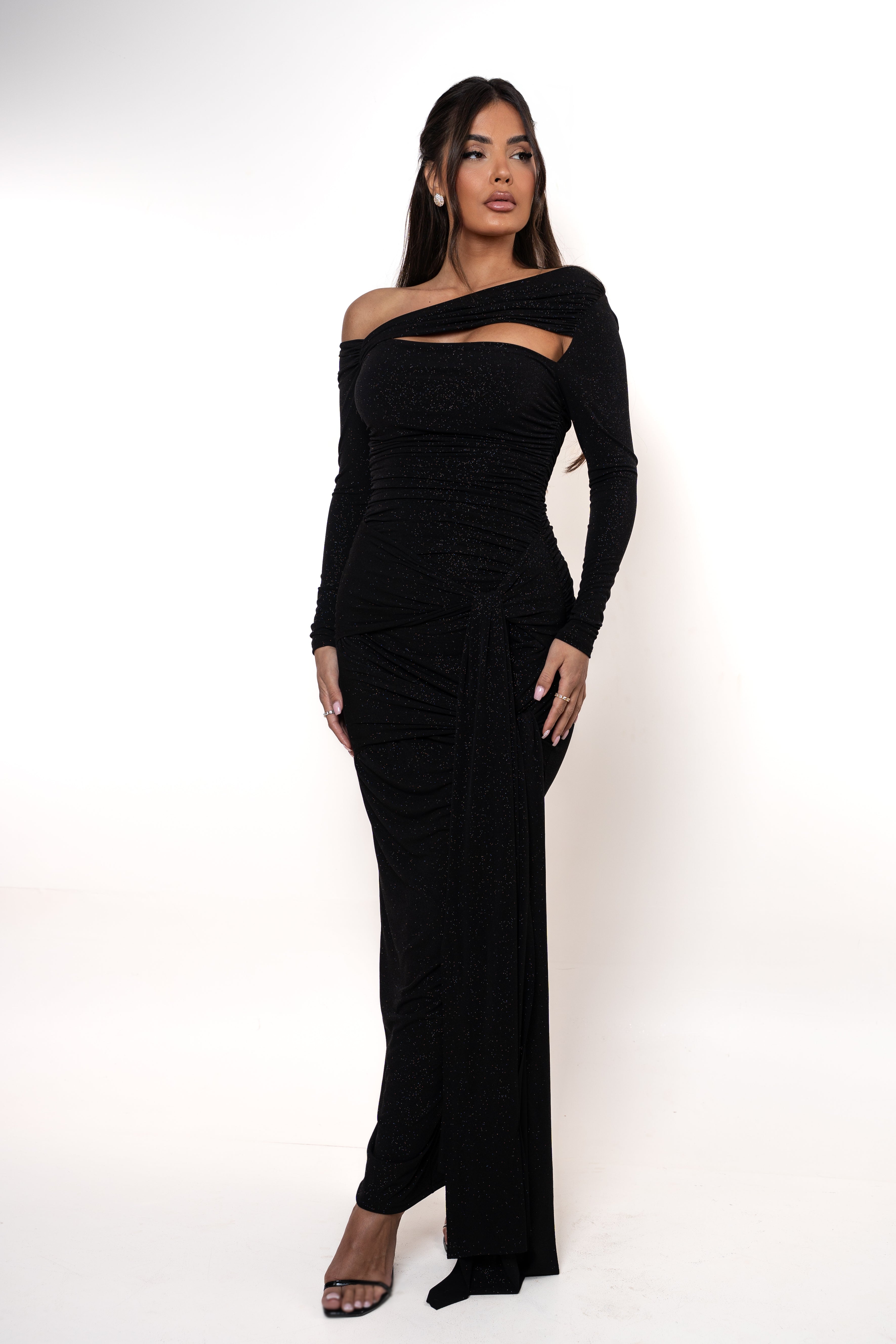 Woman wearing a black off-shoulder gown with cut-out design on a white background