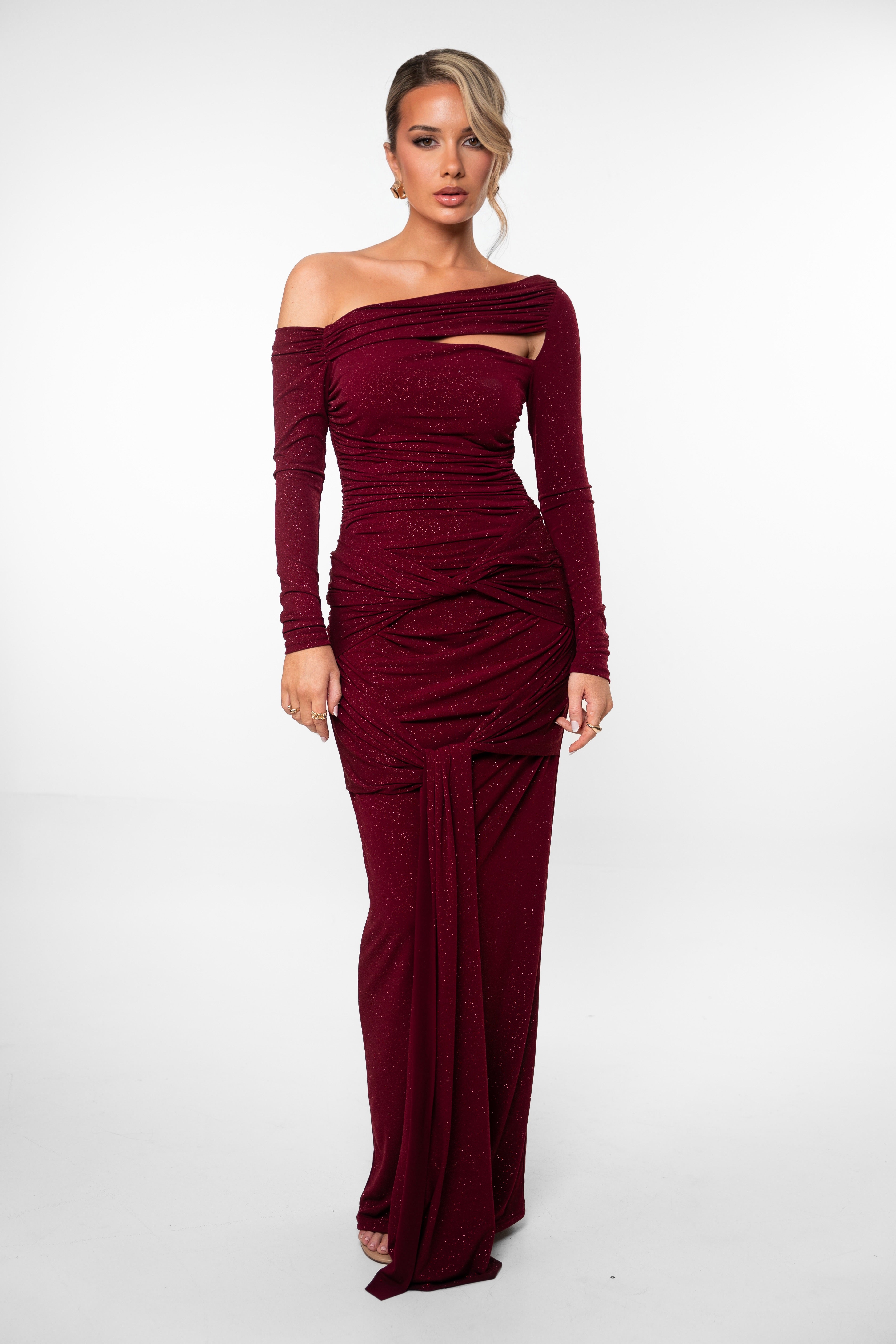 Woman wearing a burgundy off-shoulder gown on a white background
