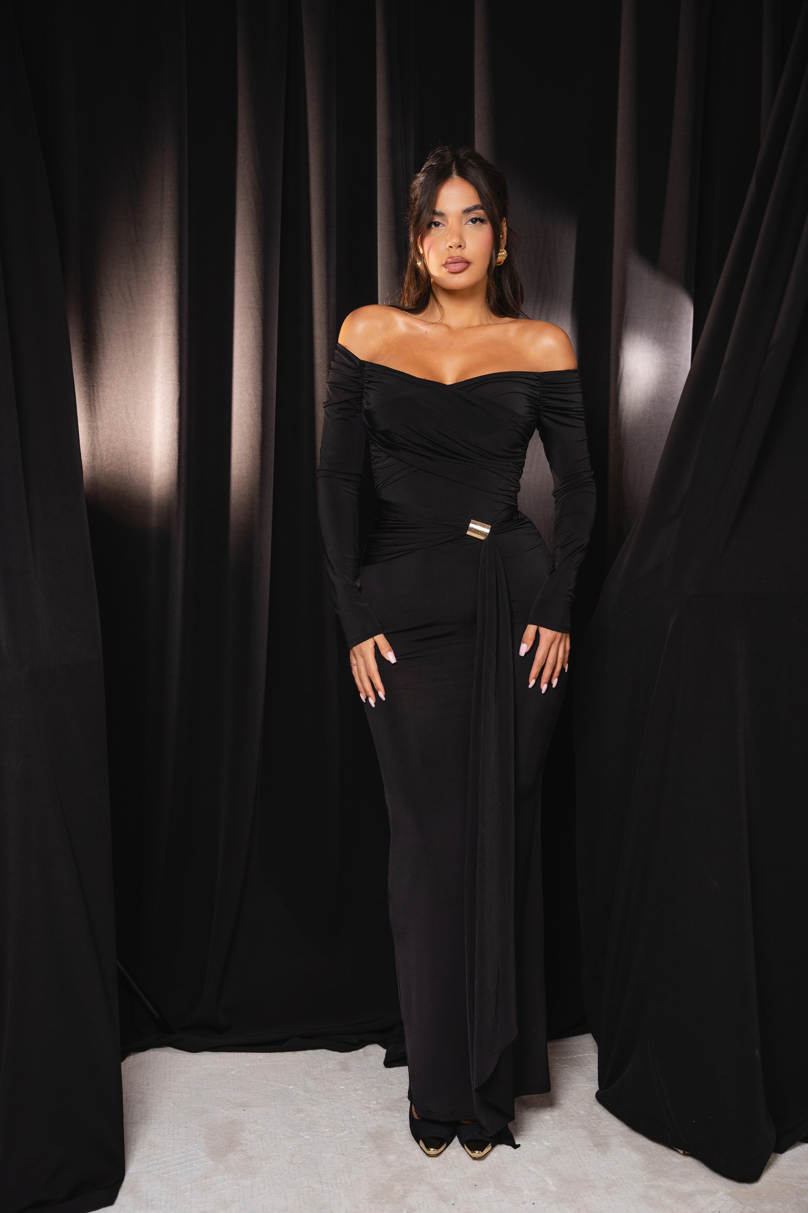 Floor-length black dress featuring a flowing front detail