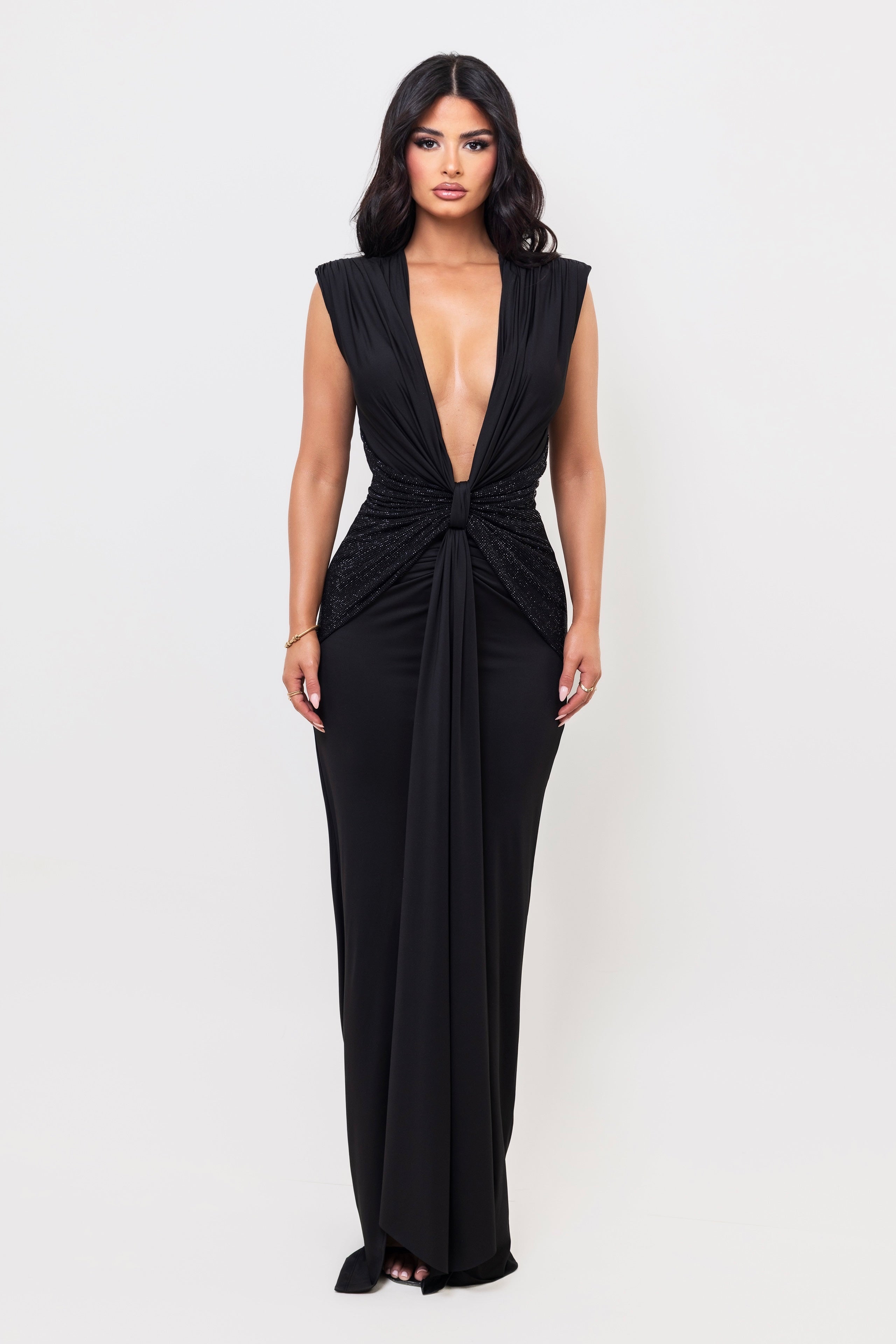 Woman wearing a black evening gown with a plunging neckline on a white background