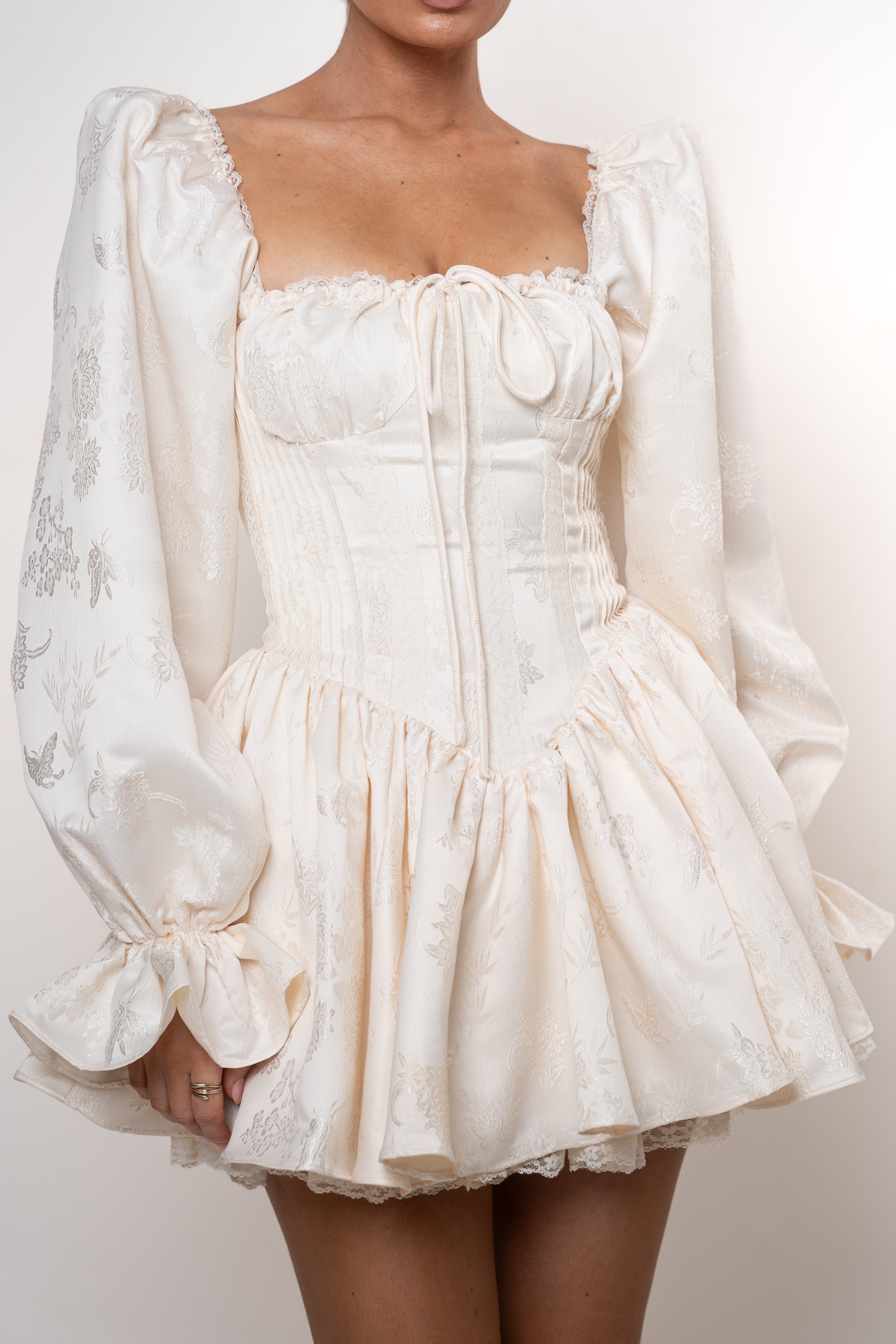 White lace dress with long sleeves on a plain background