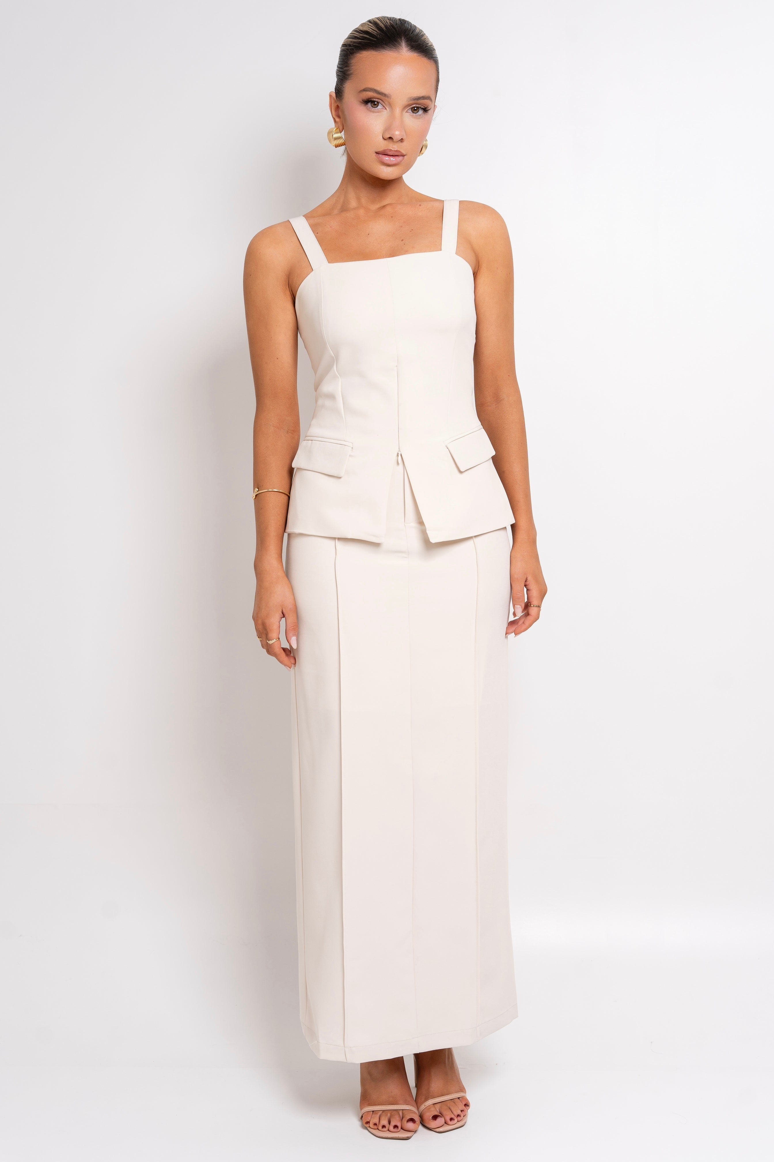 Elegant cream two-piece set with a structured top and fitted skirt.