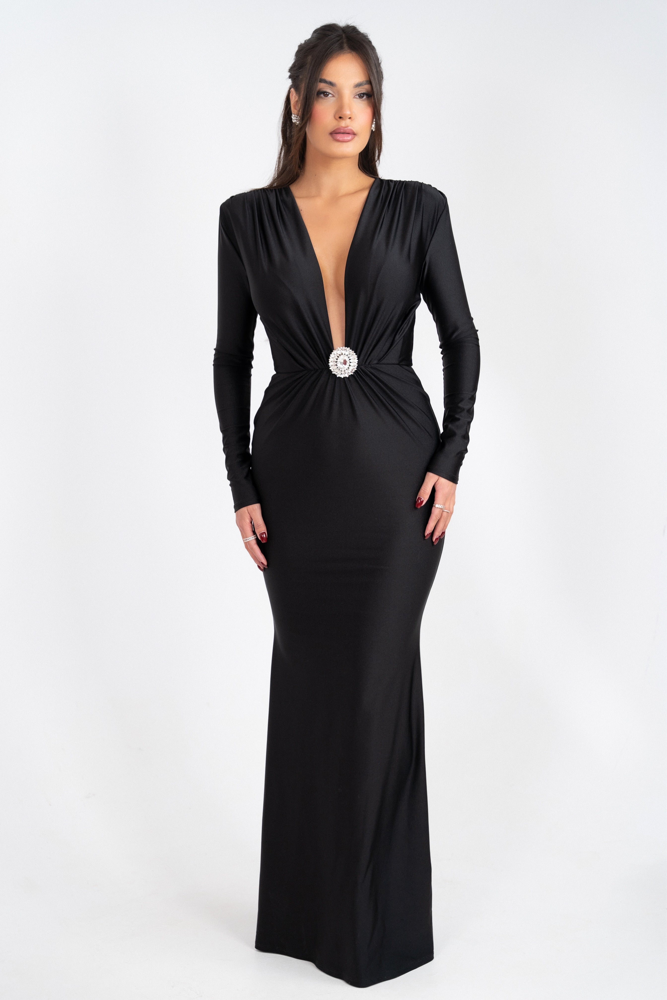 Black dress with a deep plunging neckline and a crystal-embellished detail at the waist.