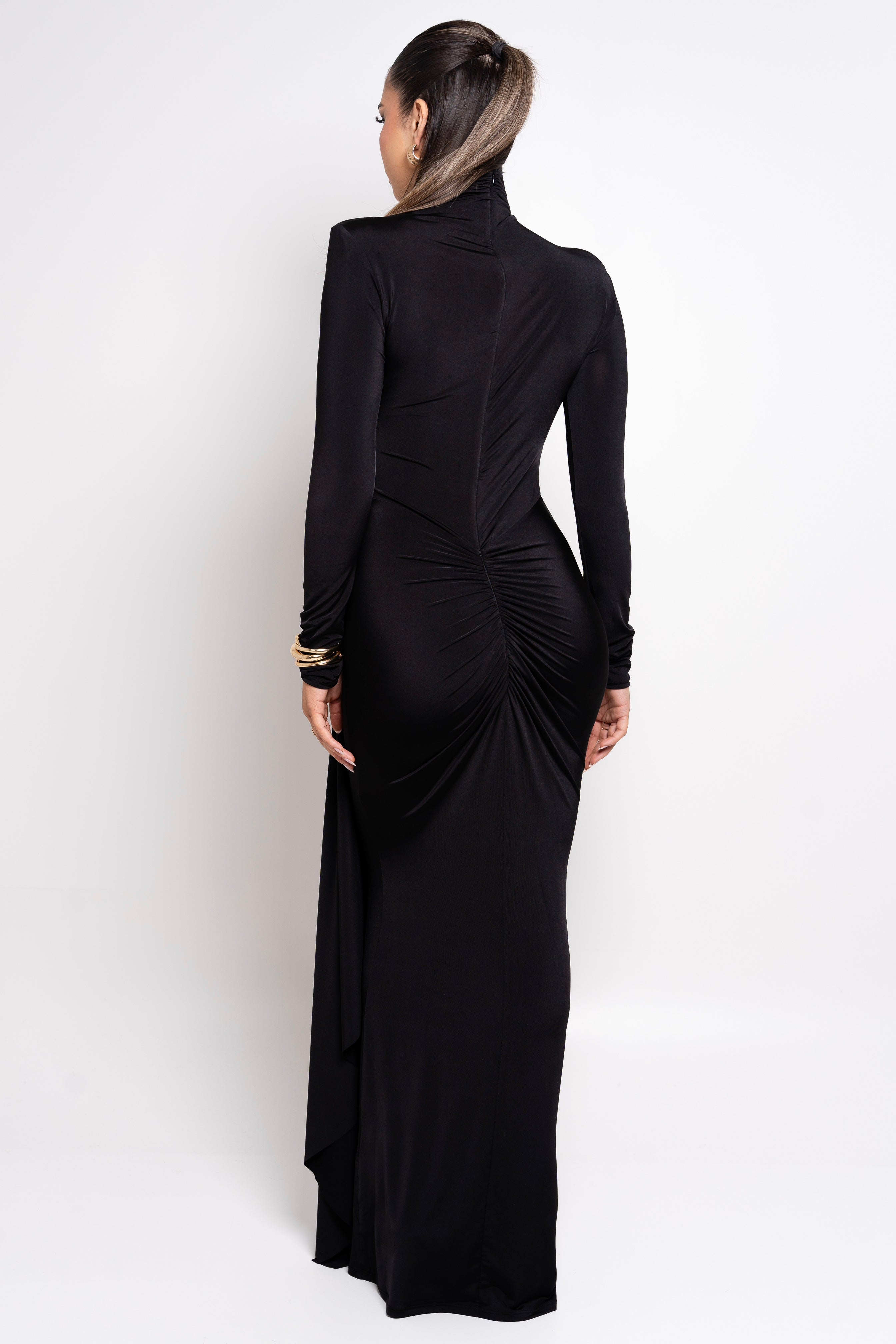 Sophisticated black maxi dress with draped detailing and a form-fitting silhouette.