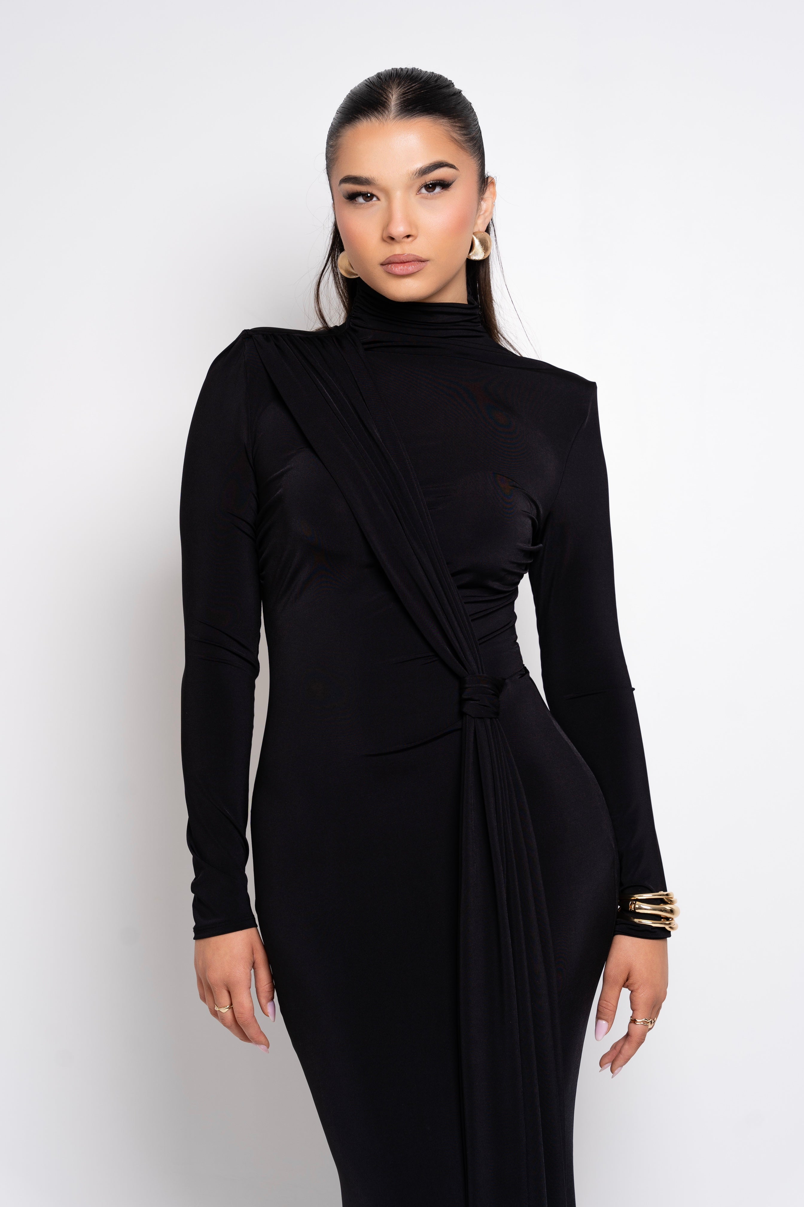 Black formal dress with a cinched waist and gathered fabric detail.