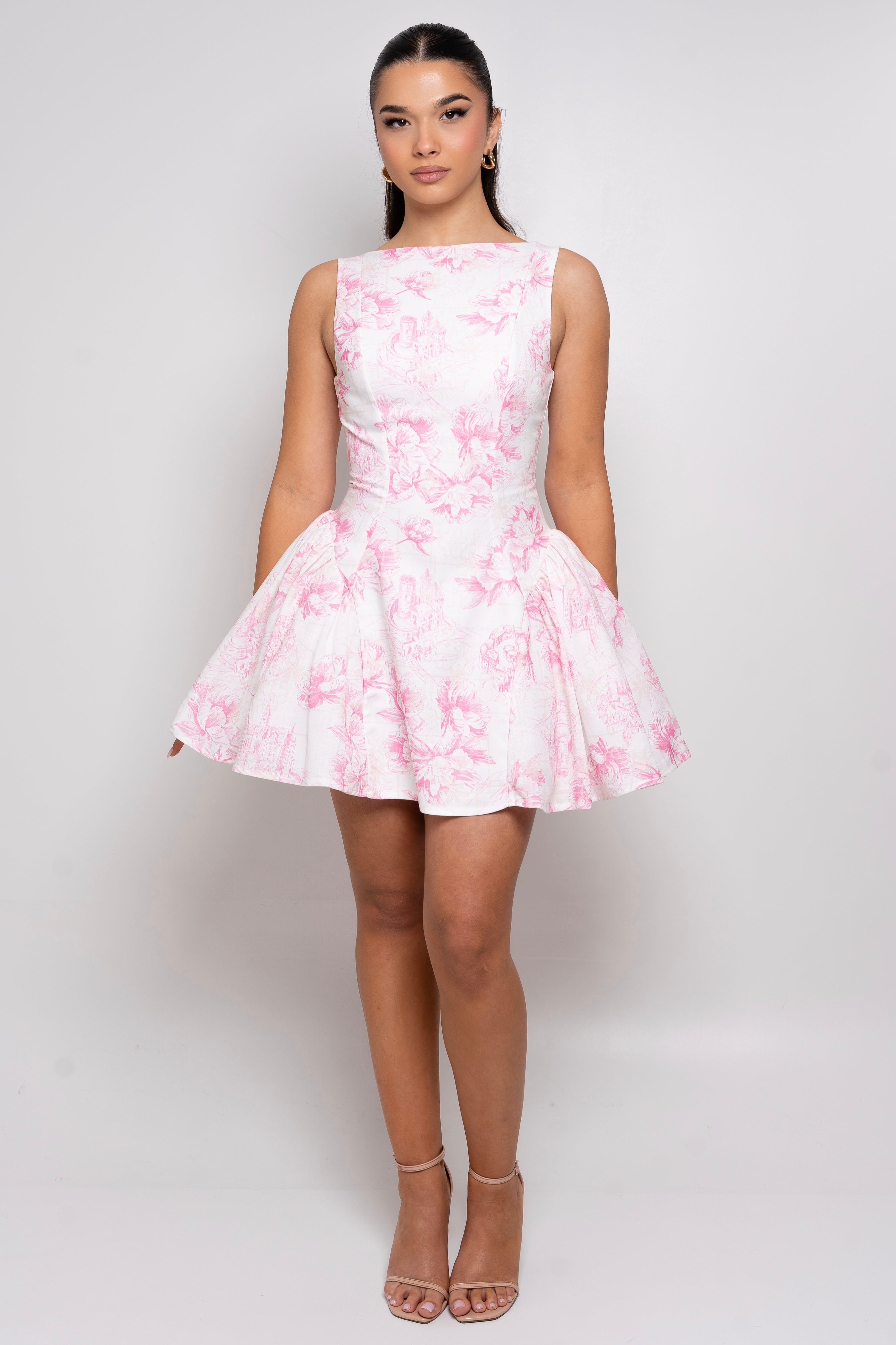 Sleeveless white mini dress with a pink floral print and a flared skirt.